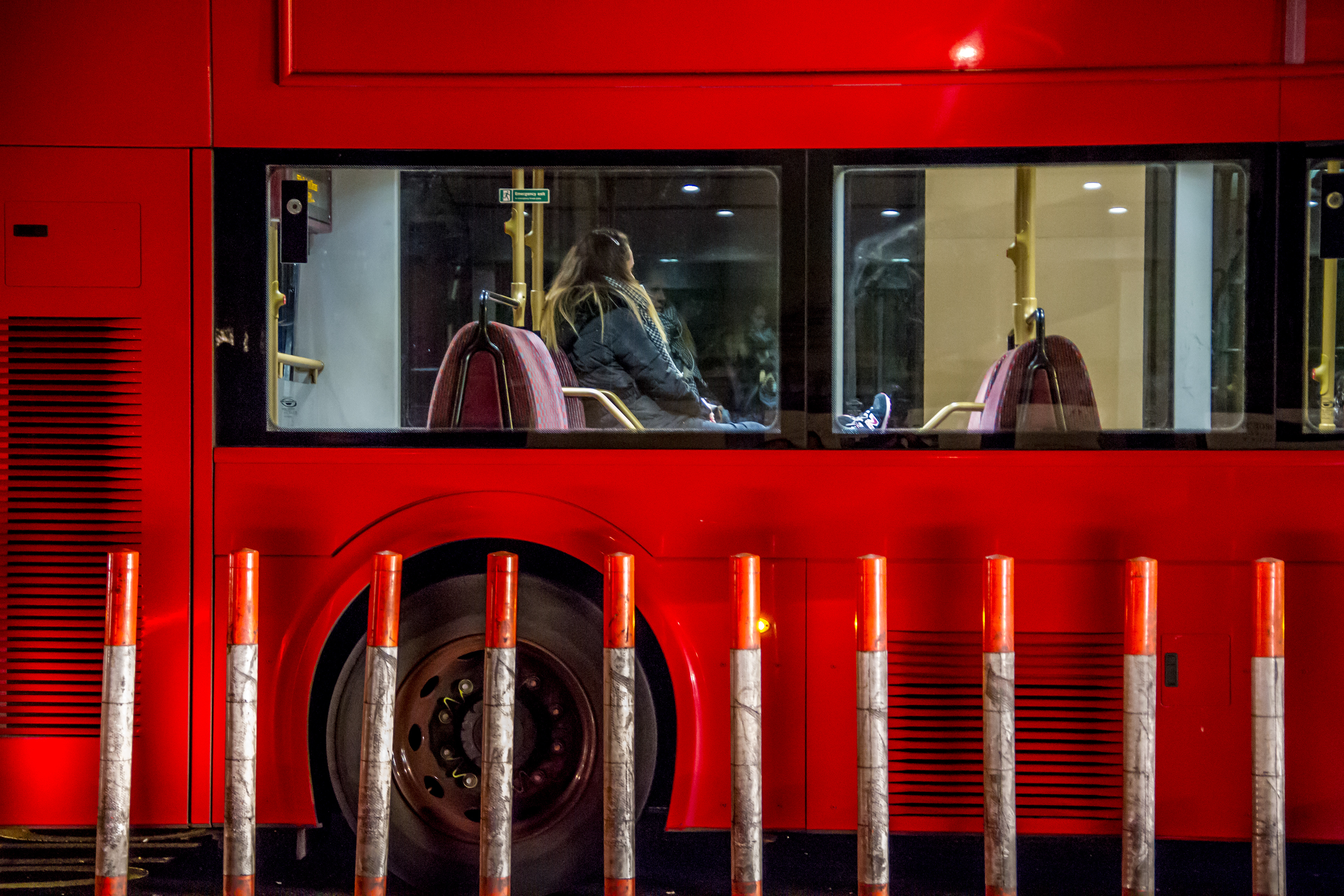 A woman rides a late night bus.
