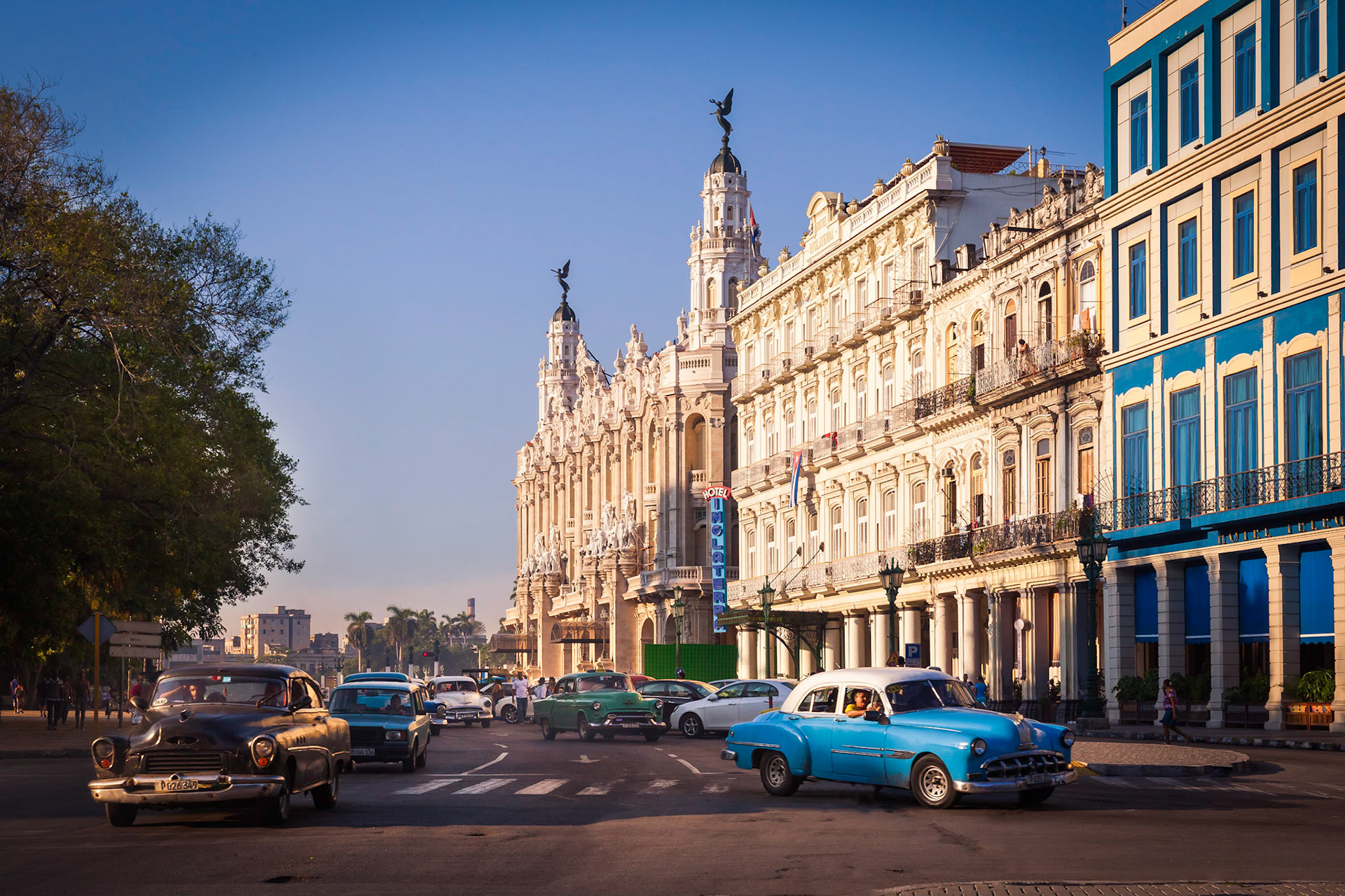Central Square (Parque Central) with Inglaterra Hotel and The Great Theater of Havana on the left, Havana, Cuba. 1950s cars drive through the street.