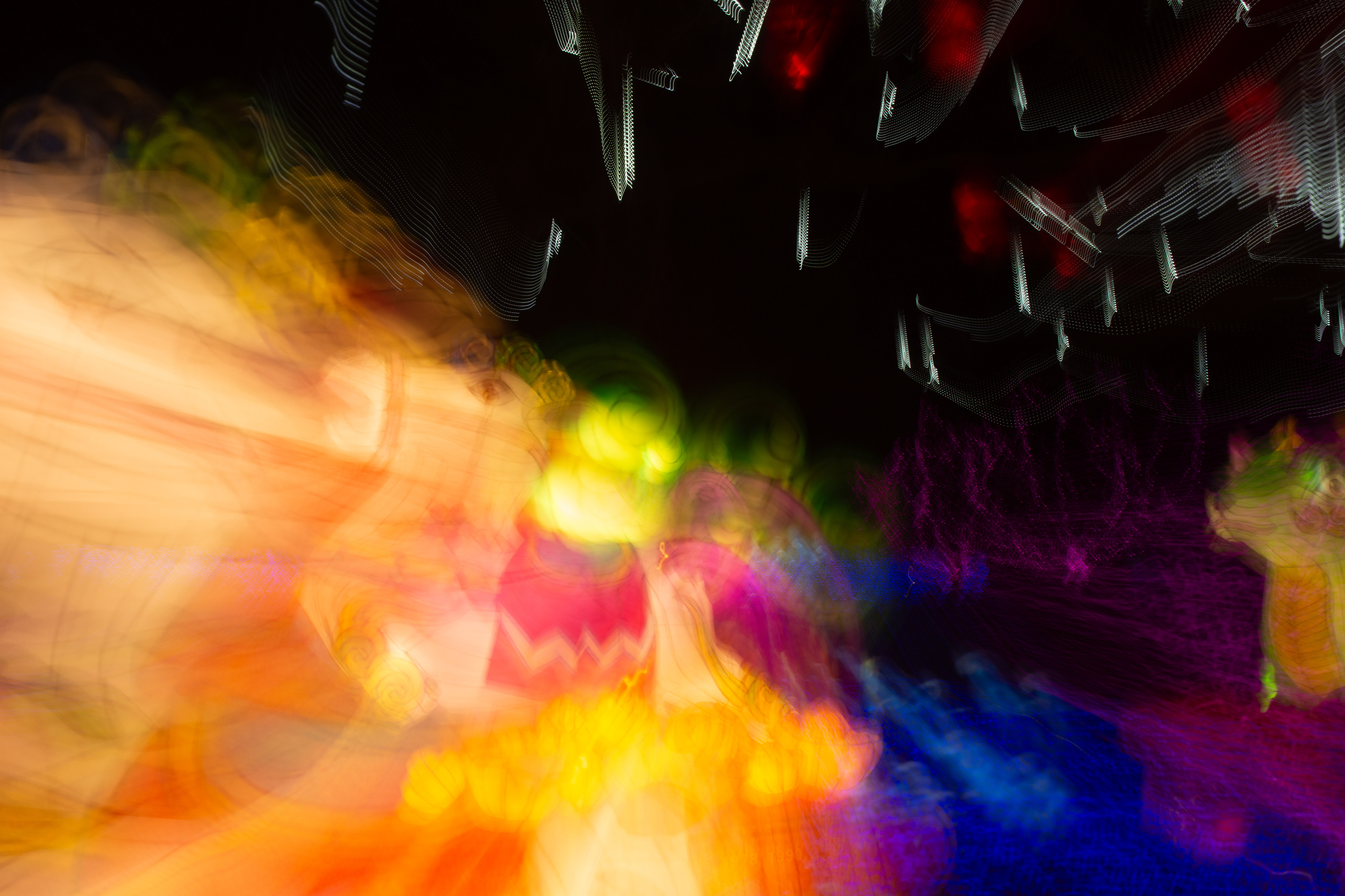 In the heart of a swirling, kaleidoscopic dreamscape, a carousel horse emerges, its form a ghostly silhouette amidst a whirlwind of vibrant colours. The horse seems to gallop through a cascade of molten rainbows, its mane and tail flowing like liquid fire. Around it, the air shimmers with electric hues of orange, pink, and blue, as if the very essence of a carnival has been set free to dance in the night. The scene is a mesmerising blend of fantasy and motion, capturing the fleeting magic of a carousel ride in a world where reality blurs into imagination.