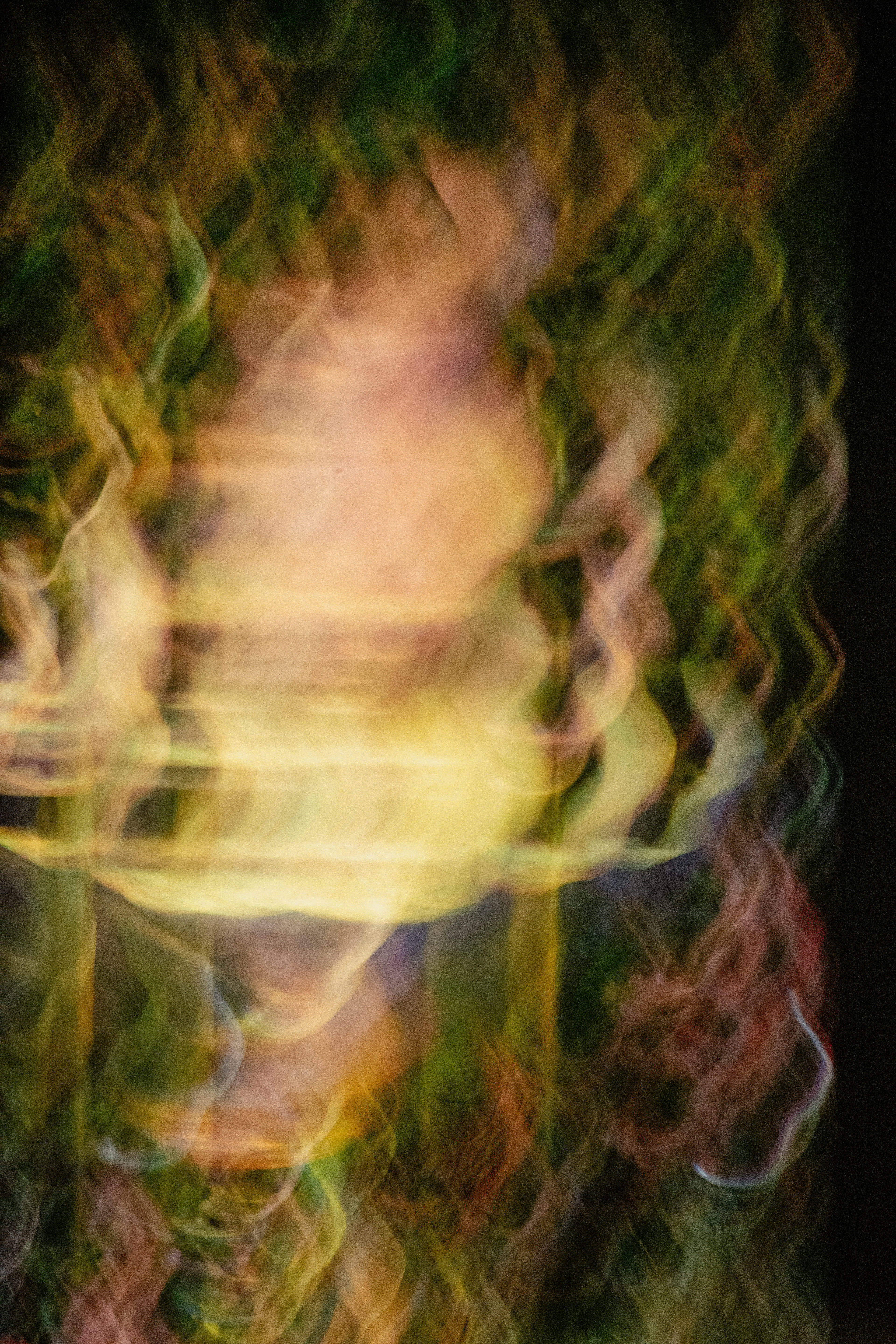 'Gentle Ethereal Drift'  (2025). Swirling ribbons of vibrant colour dominate the image, blending together in a whirl of movement. Shades of yellow, green, pink, and touches of orange and purple merge and twist into each other, creating a layered, textured effect reminiscent of brushstrokes in an impressionist painting. The colours are mingled with wispy, almost smoke-like trails, producing a sense of depth as some areas appear more translucent while others are more saturated and glowing. The overall texture feels soft and fluid, with undulating lines and curves giving it an energetic, dynamic feel—almost like looking at a moving reflection on water or viewing gauzy fabric illuminated by coloured lights.