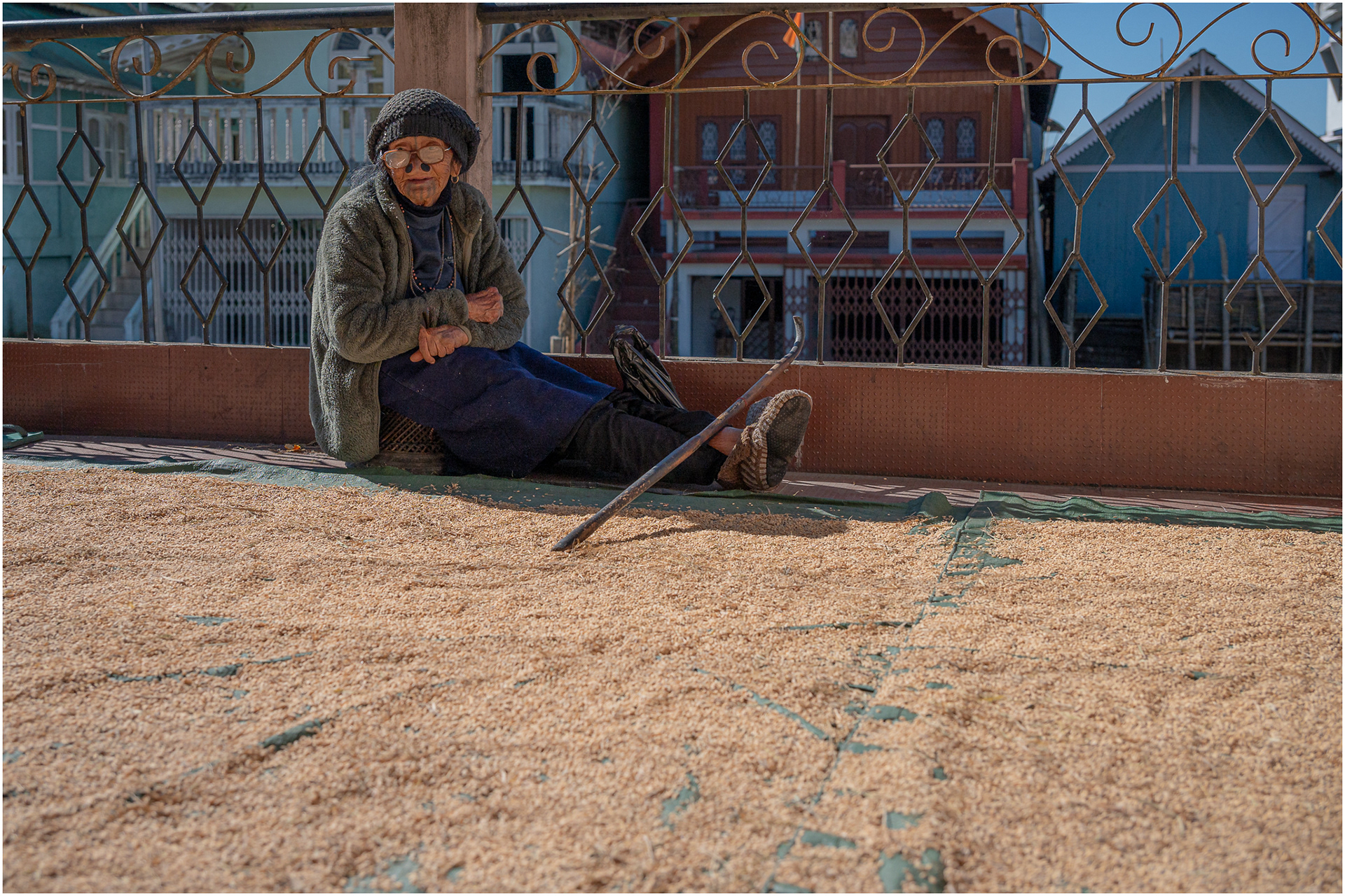 An Apatani woman sits in front of harvested rice
