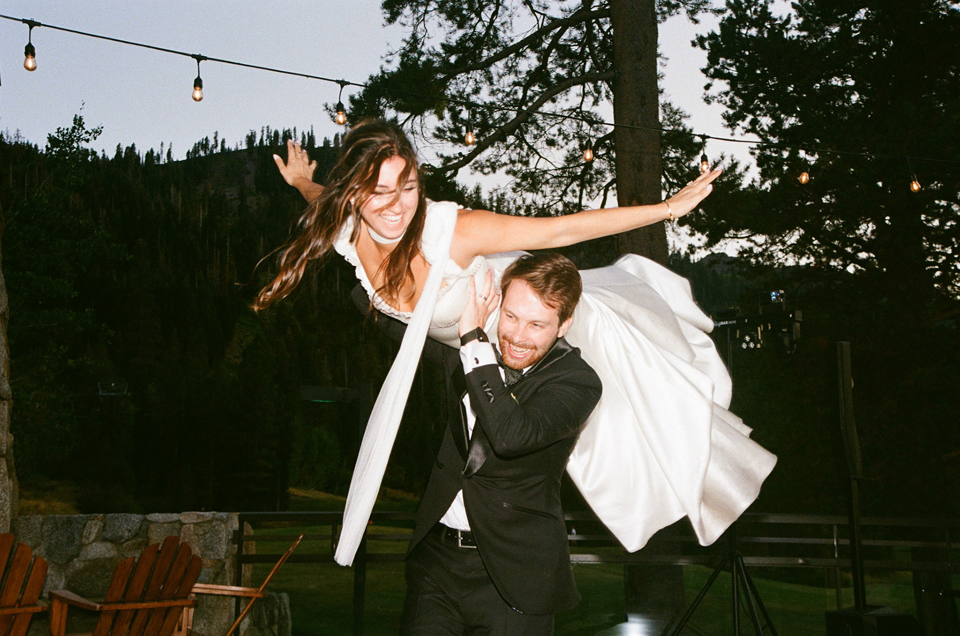 Cami, Tyler, and their guests celebrating beneath the string lights at Everline Resort.