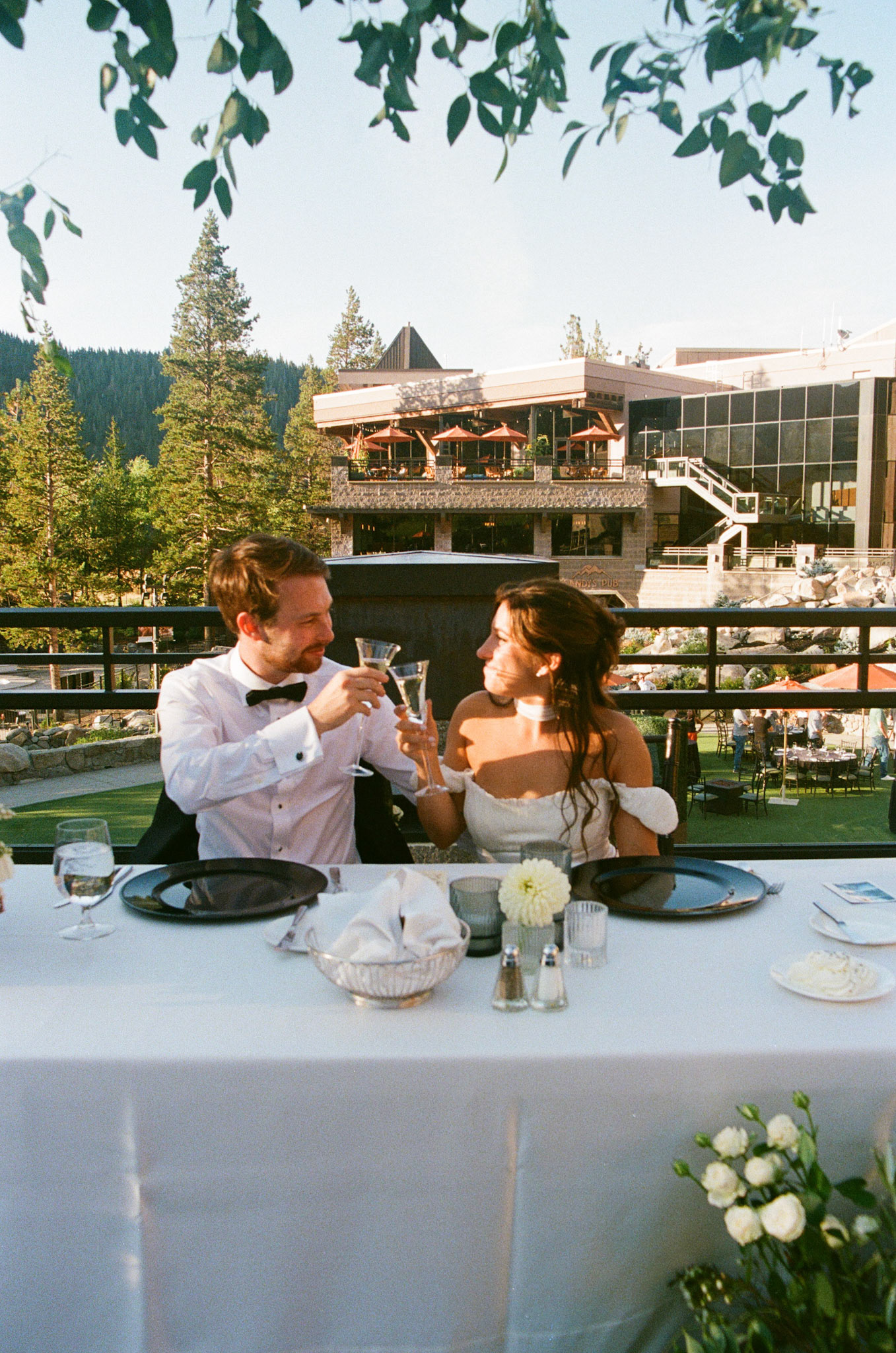 Cami, Tyler, and their guests celebrating beneath the string lights at Everline Resort.