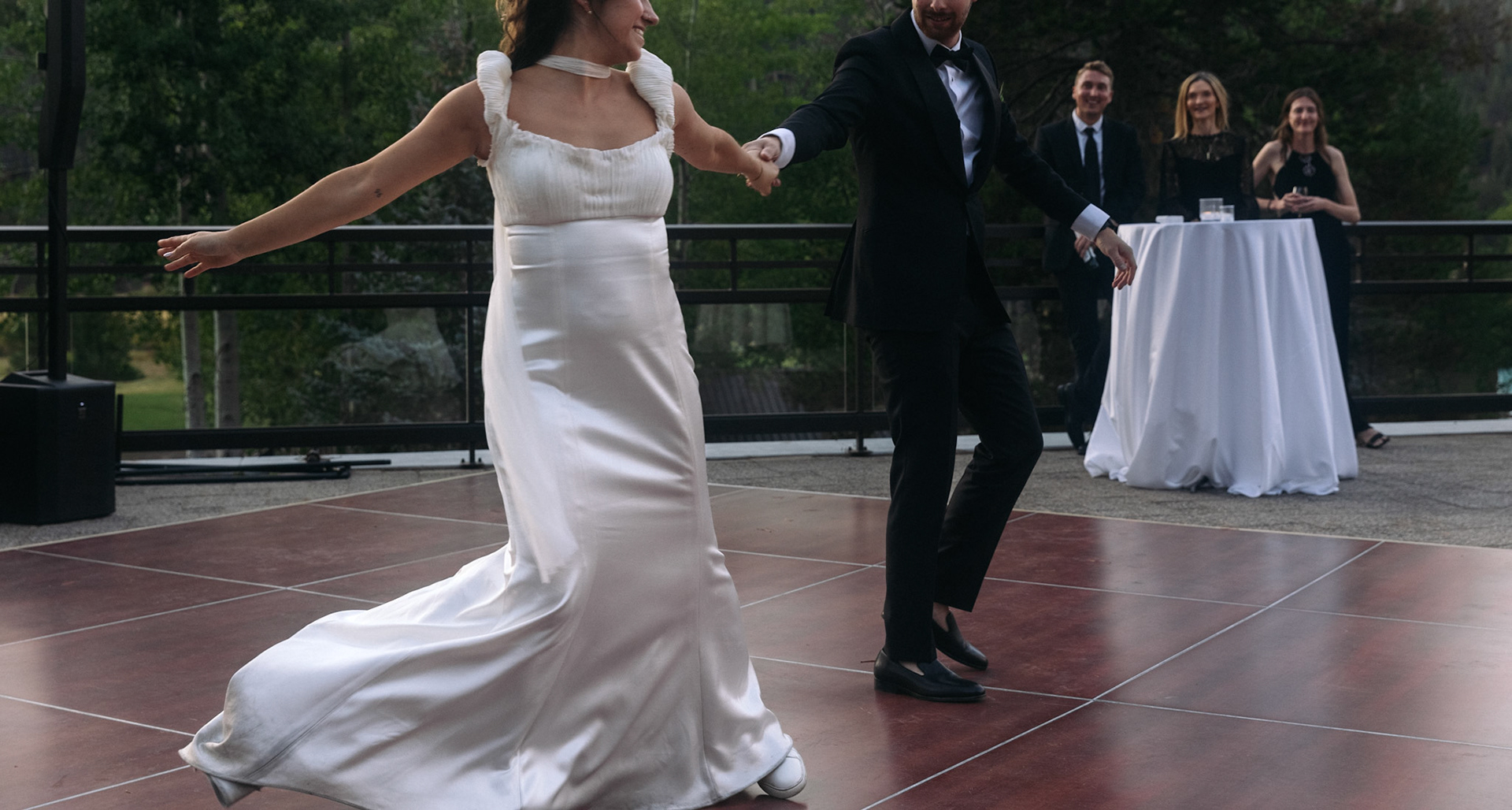Cami, Tyler, and their guests celebrating beneath the string lights at Everline Resort.