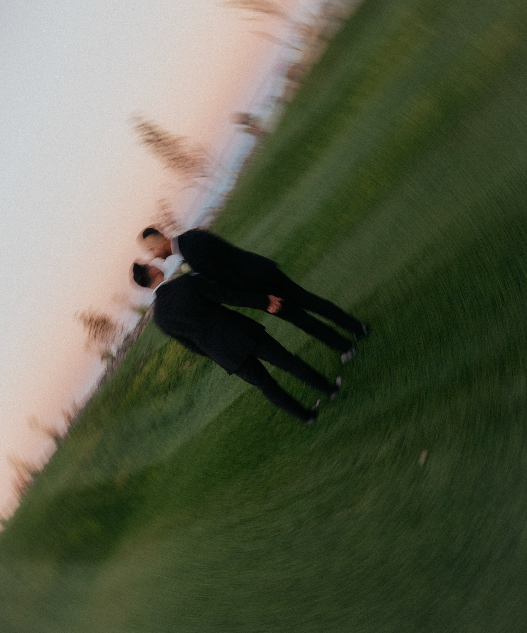 Two grooms kiss in an intentionally blurred film photograph at their Reno wedding.