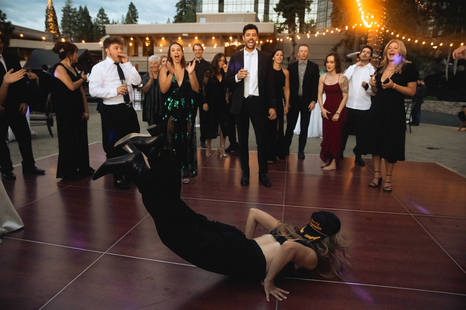 Cami, Tyler, and their guests celebrating beneath the string lights at Everline Resort.