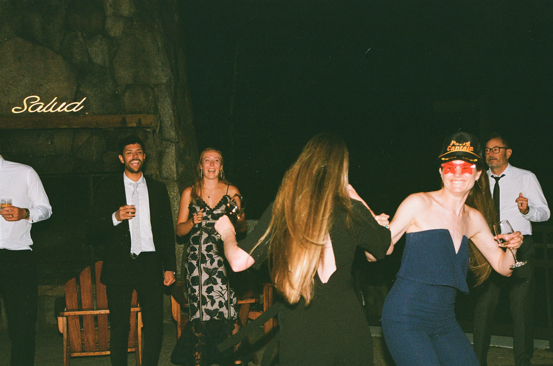 Cami, Tyler, and their guests celebrating beneath the string lights at Everline Resort.