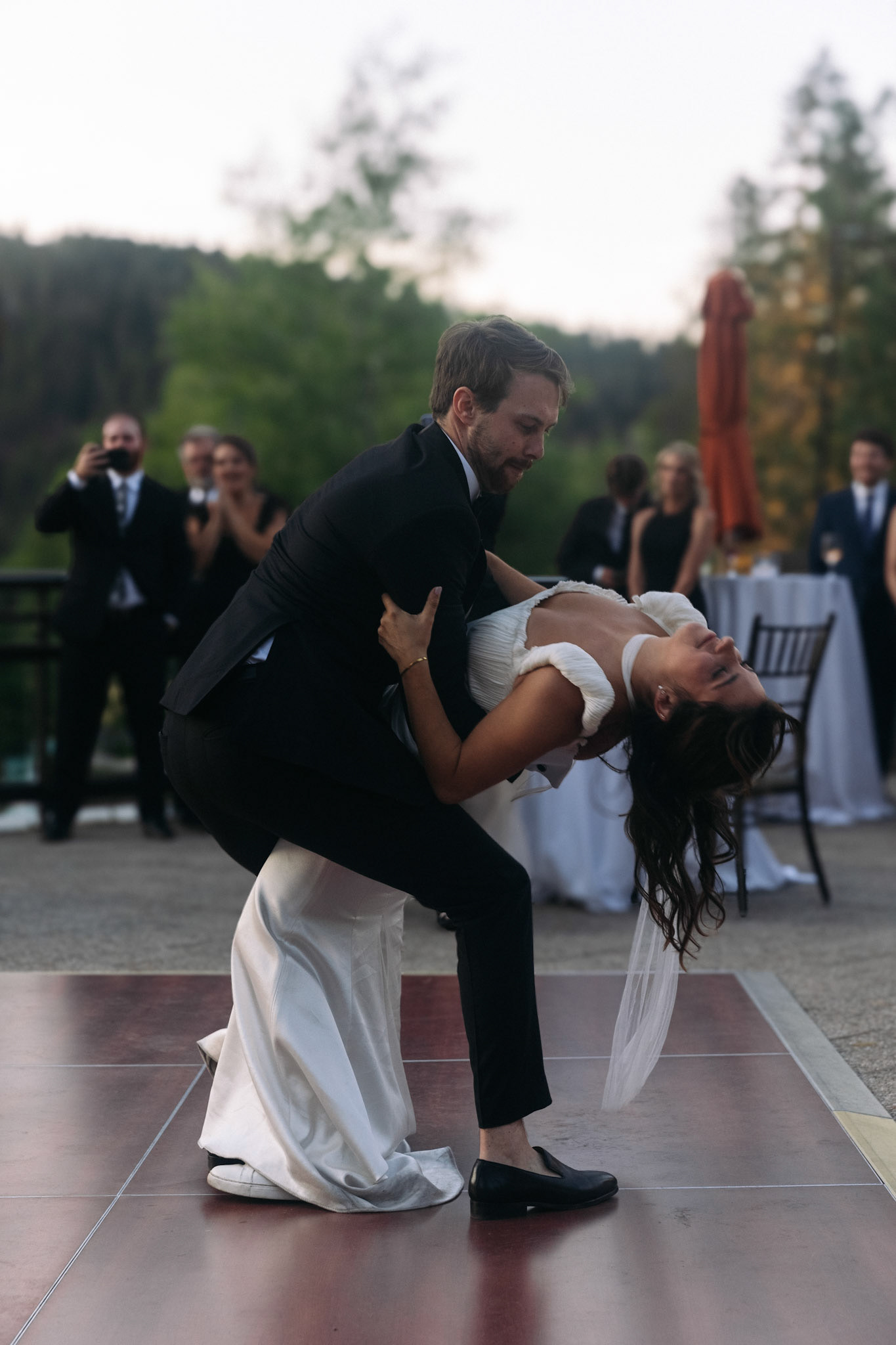 Cami, Tyler, and their guests celebrating beneath the string lights at Everline Resort.