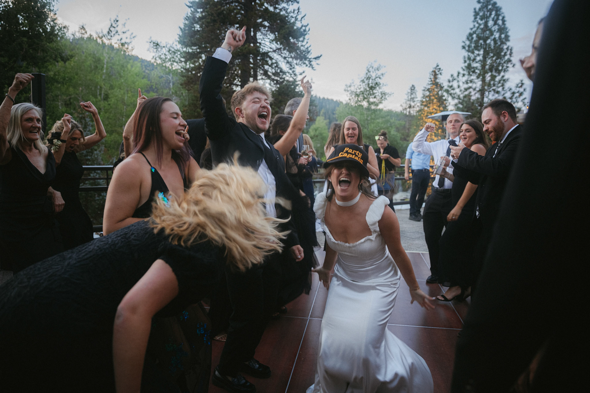 Cami, Tyler, and their guests celebrating beneath the string lights at Everline Resort.