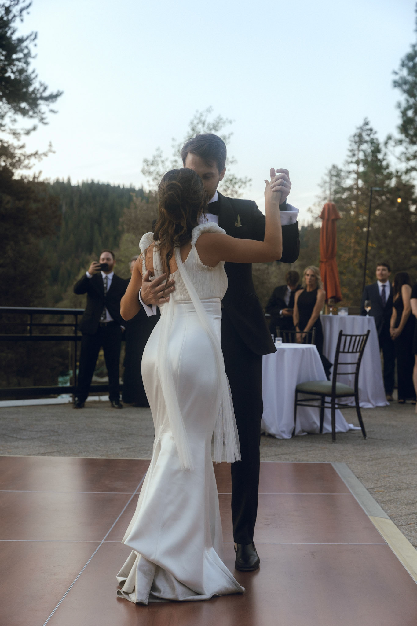 Cami, Tyler, and their guests celebrating beneath the string lights at Everline Resort.