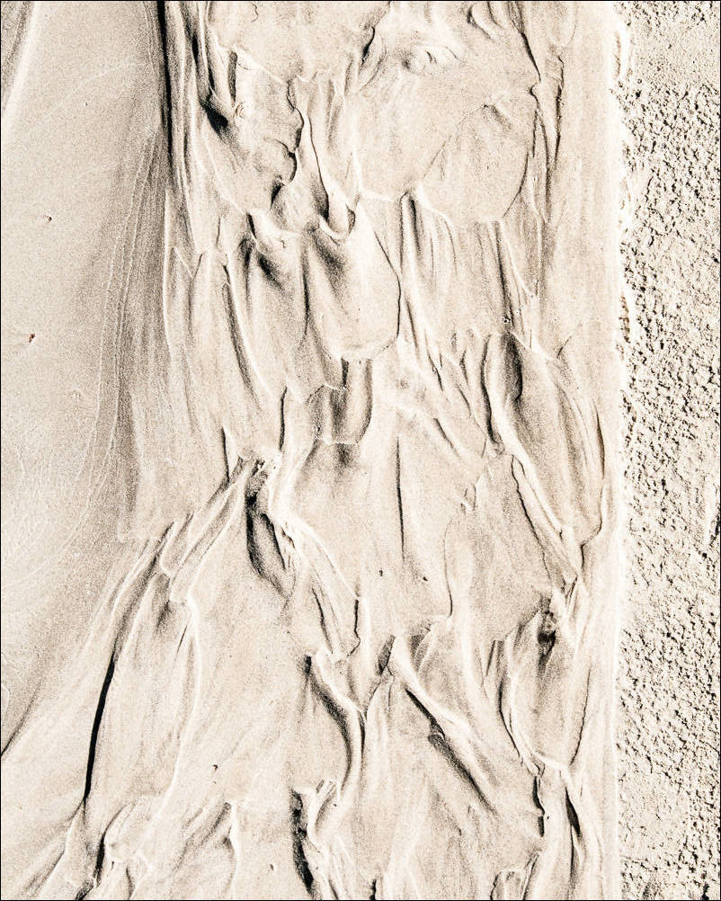 abstract flows in the sand left by the tides