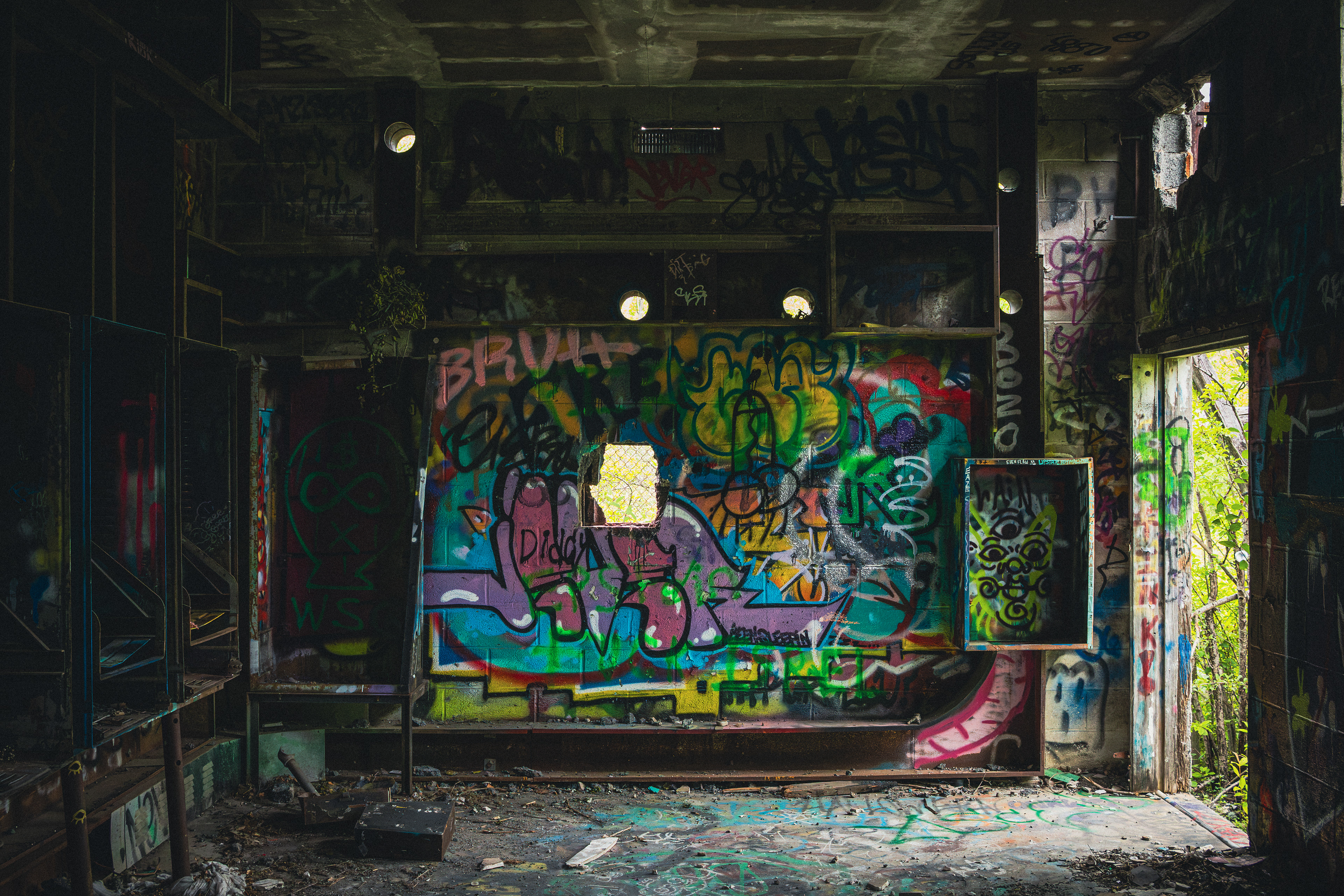 Graffiti-covered room inside an abandoned building, illuminated by light from outside.