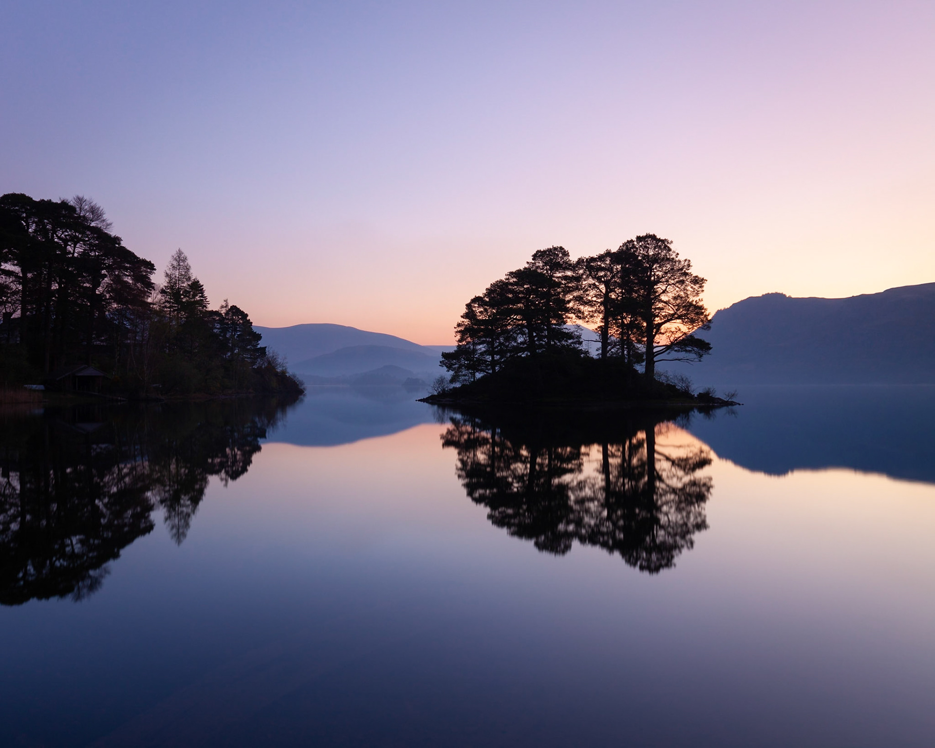 Dawn over a calm Derwent Water, The Lake District, England.