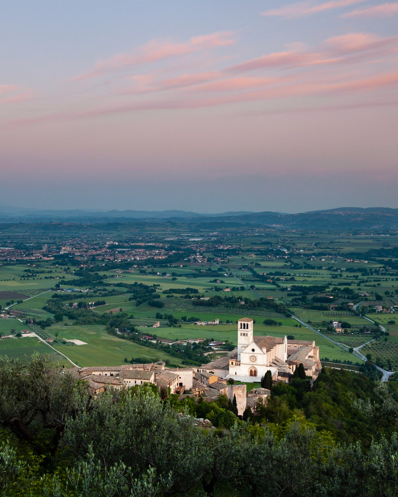 Dawn view over the Basilica of San Francesco d'Assisi towards the plains below Assisi, Assisi, Umbria, Italy