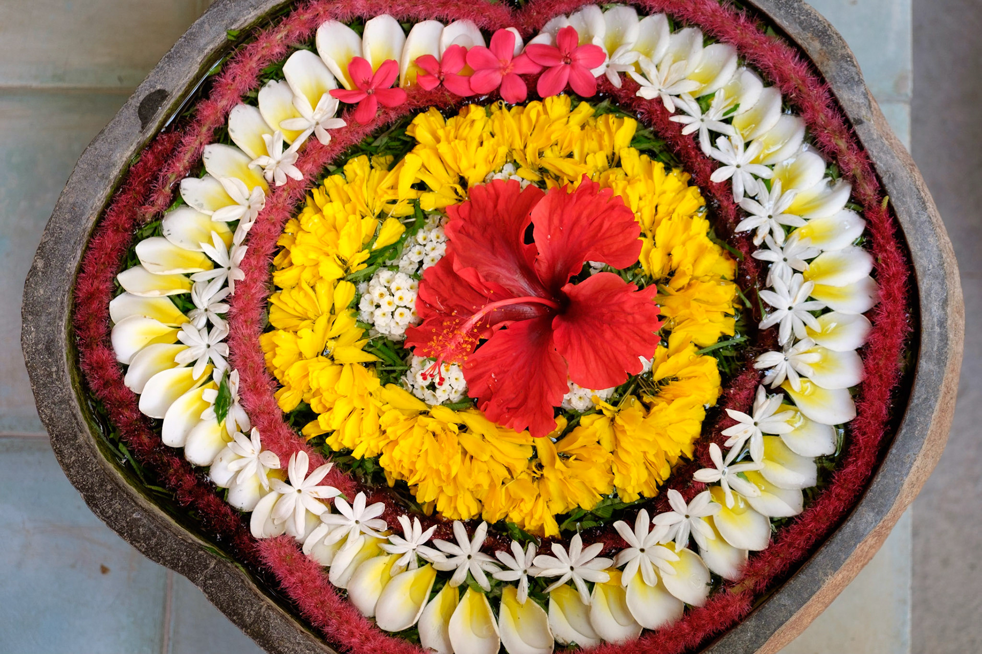 A water flower arrangement in a stone bowl, Ashyana Candidasa Resort, Bali, Indonesia.