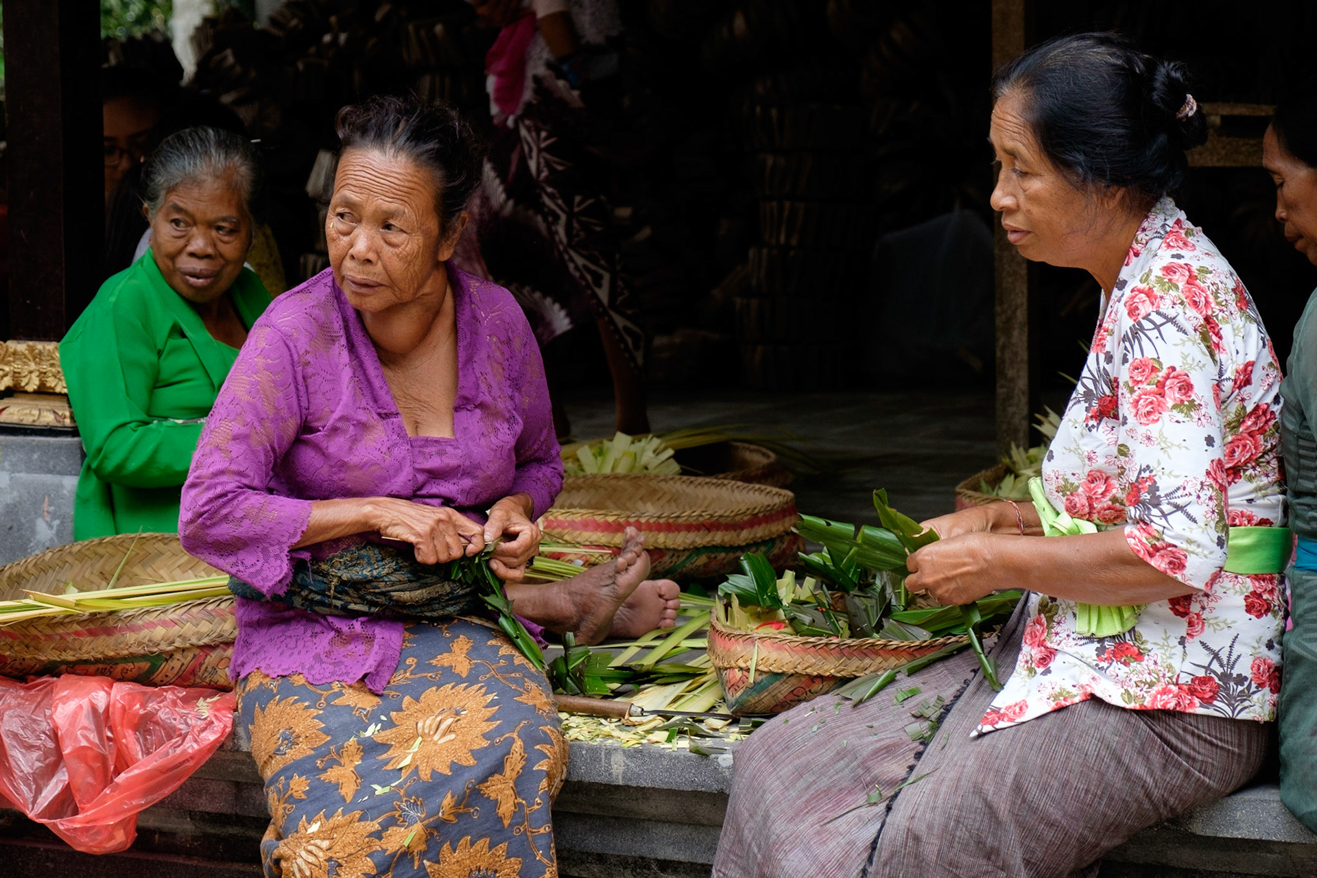 Women making offering baskets, Gunung Kawi Temple, Ubud, Bali, Indonesia.