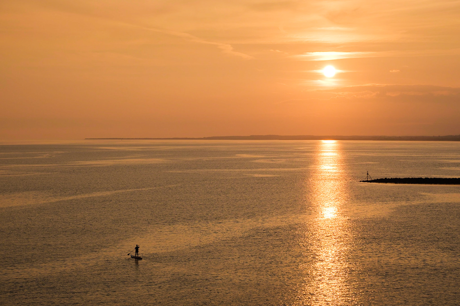 Moya paddle boarding at sunset on the River Loughor estuary.