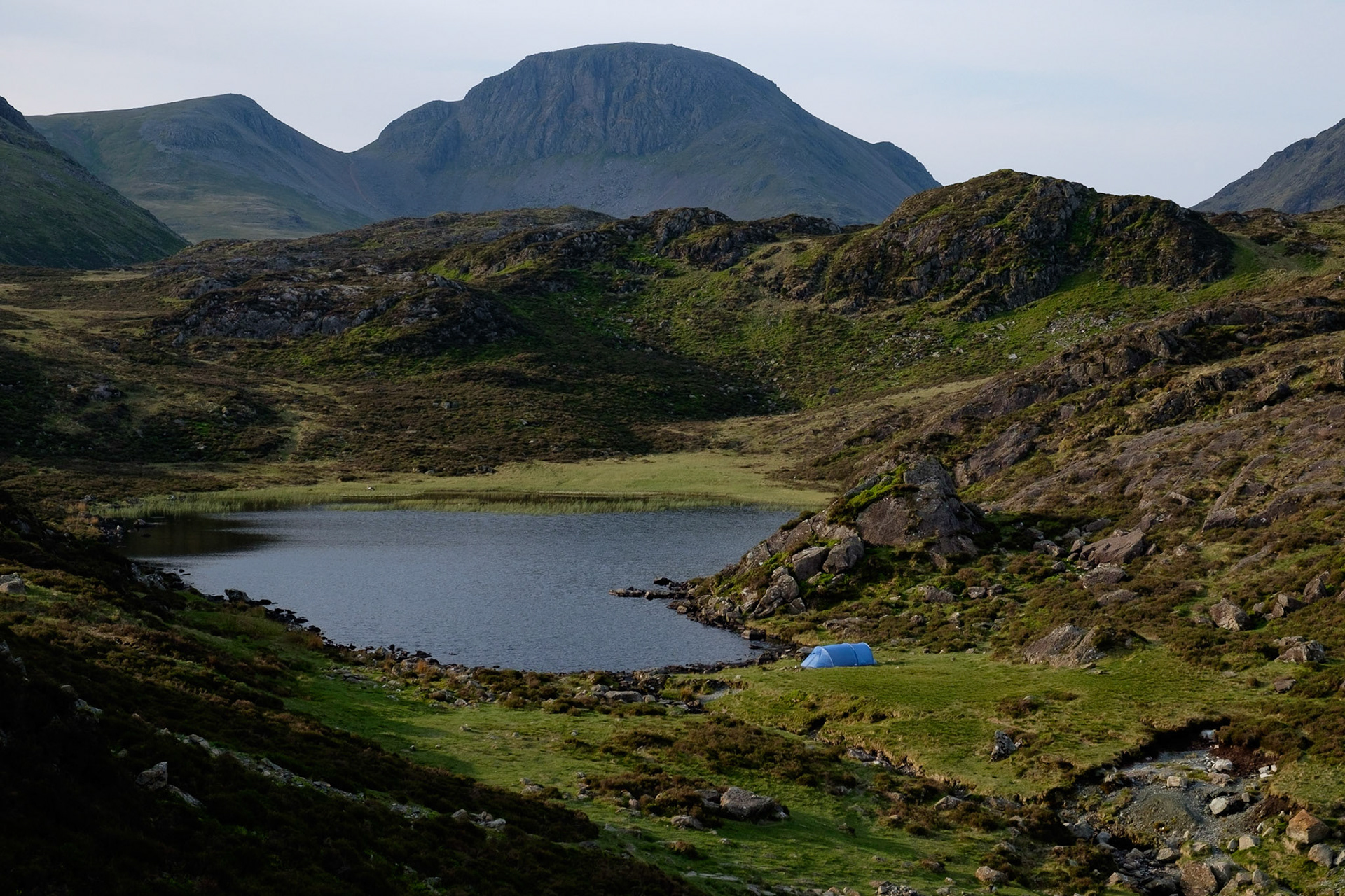 Wild camping at Blackbeck Tarn with Great Gable in the background, Lake District National Park, England.