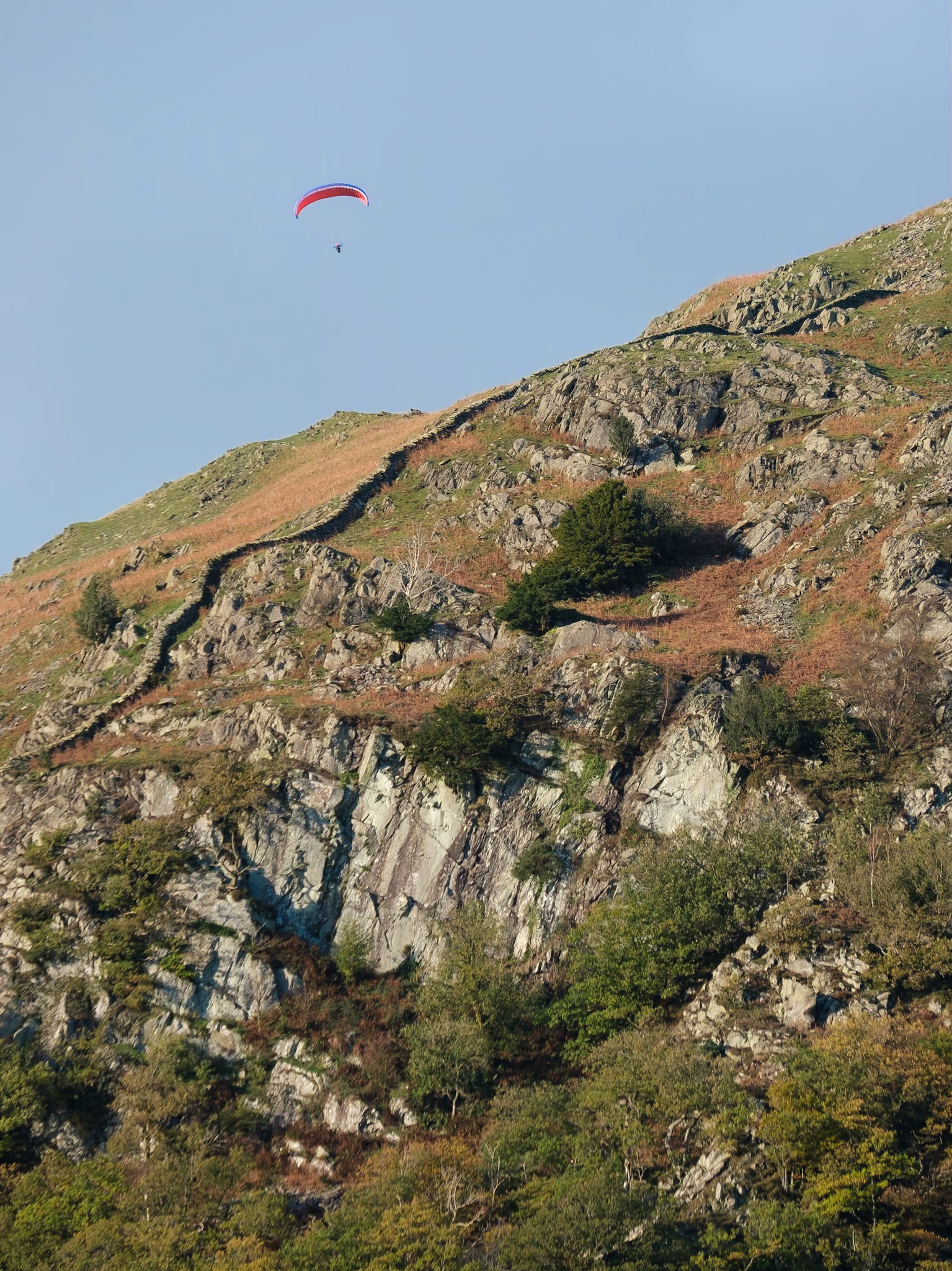 A paraglider enjoying the evening thermals above Nab Scar.