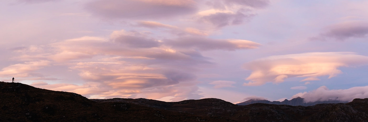 A photographer (Matt) stands on a ridge surrounded by spectacular lenticular clouds.