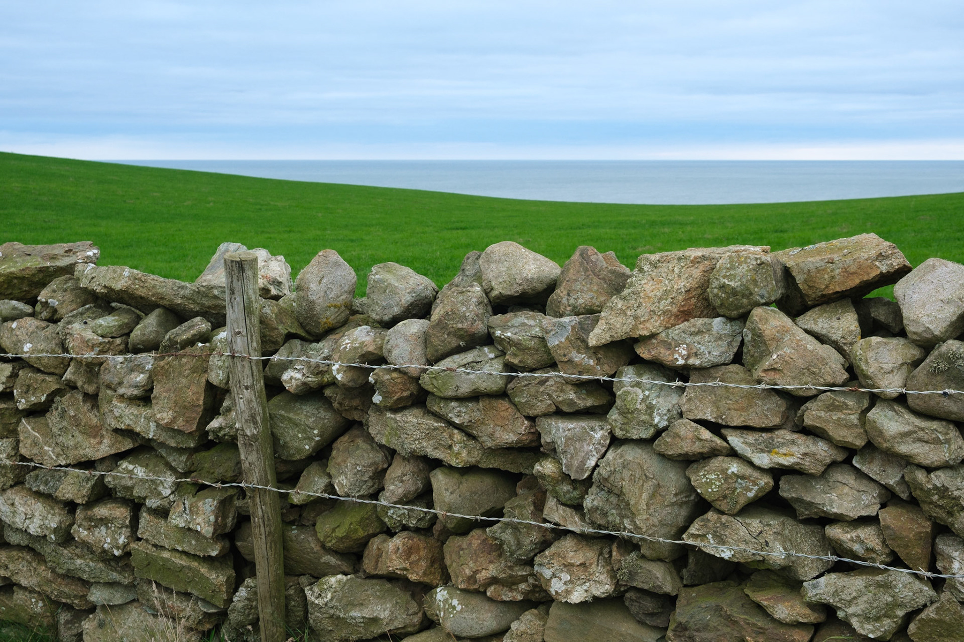 Stone wall, fields and sea.