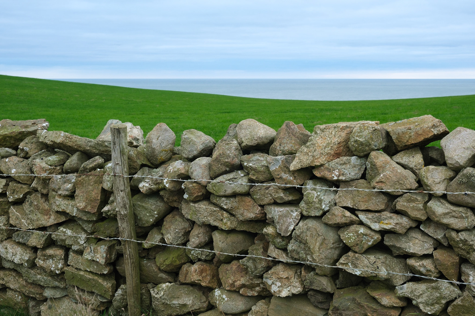 Stone wall, fields and sea.