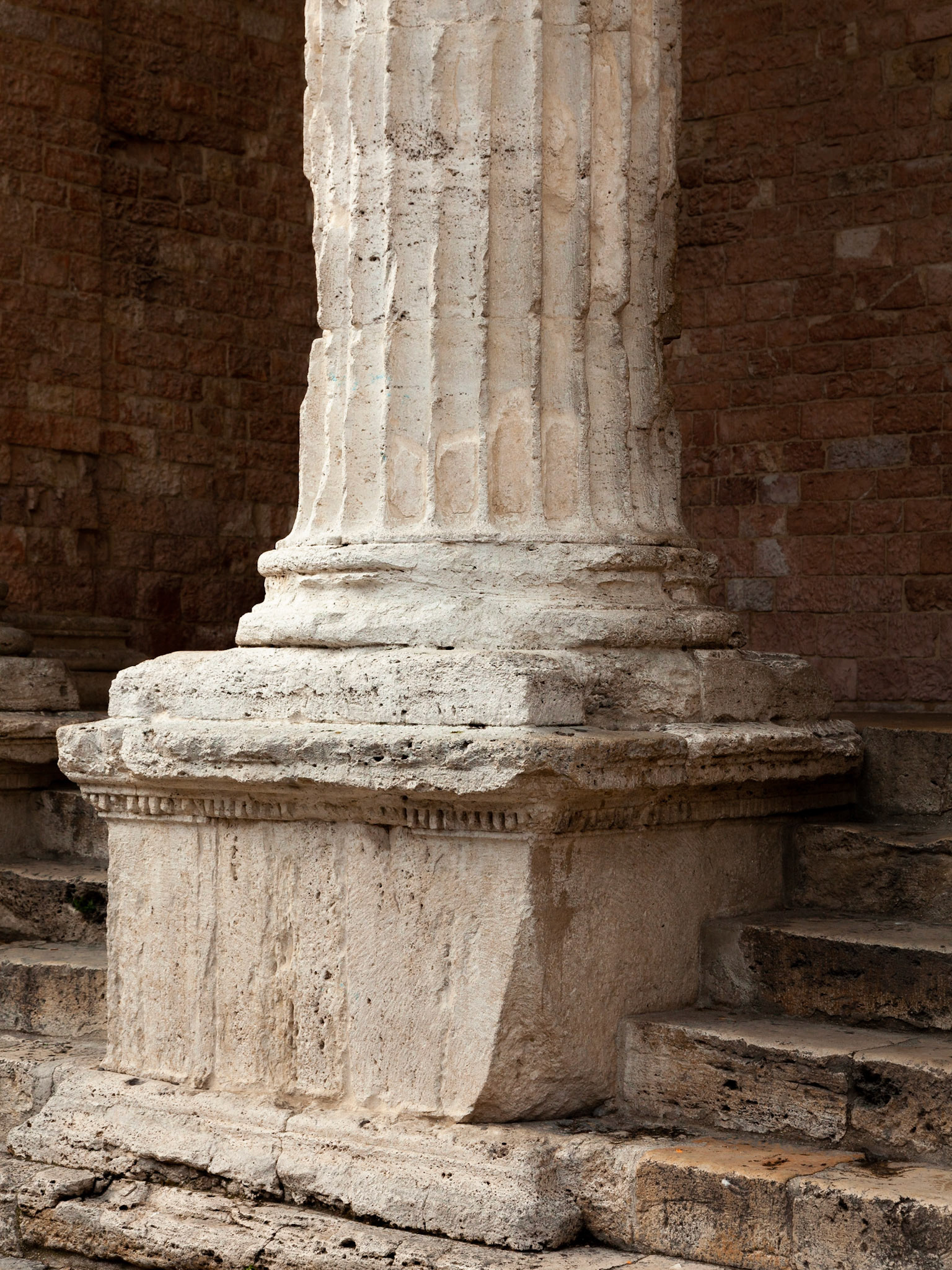 A weathered marble column of the Church of Santa Maria sopra Minerva, Assisi, Umbria, Italy.
