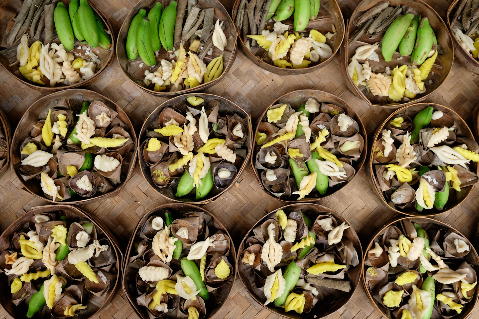 Preparing offerings for tomorrow's knowledge day celebration at Gunung Kawi Temple, Ubud, Bali, Indonesia.