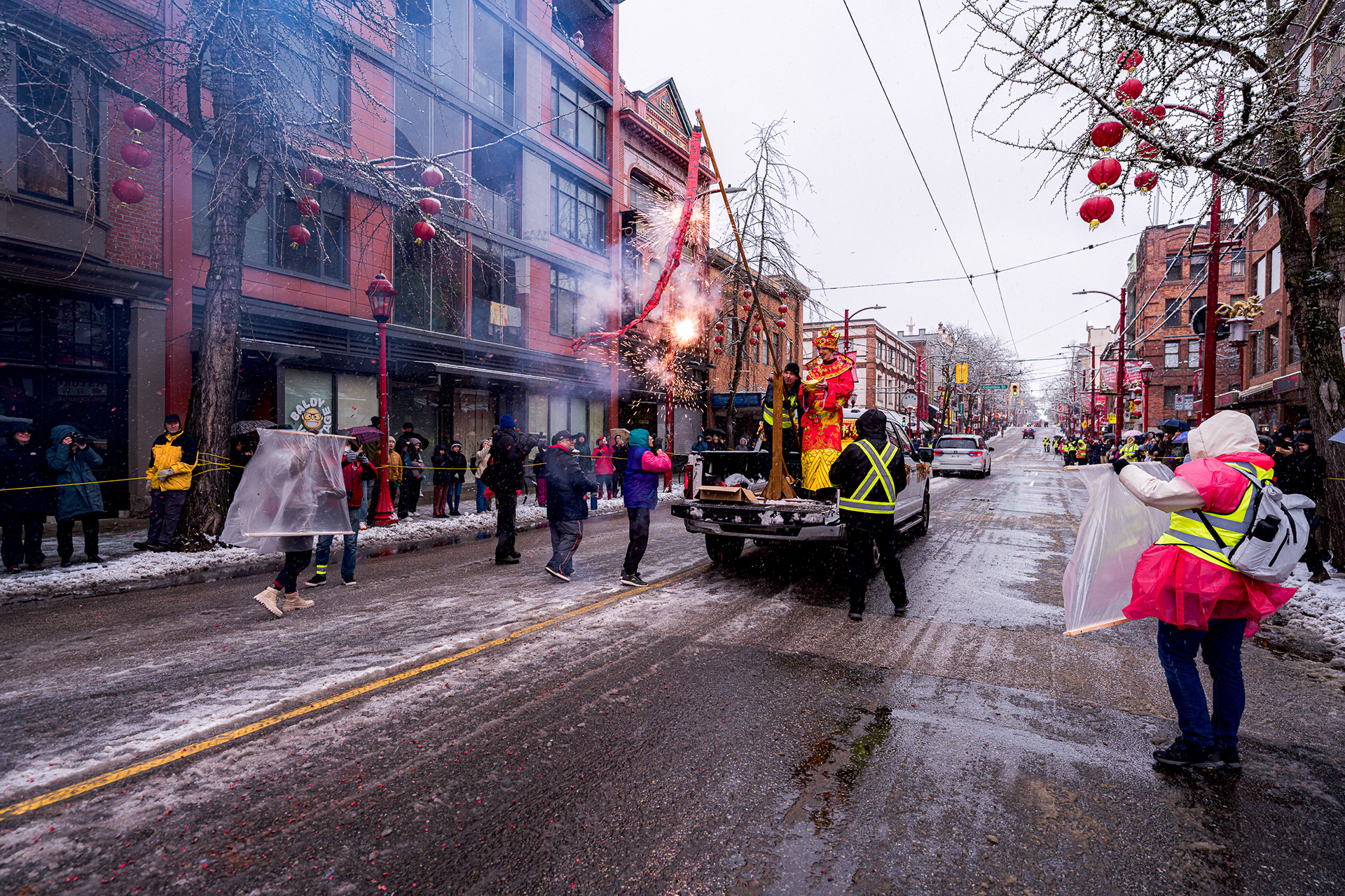 Firecrackers exploding in smoke and snow on Pender Street.