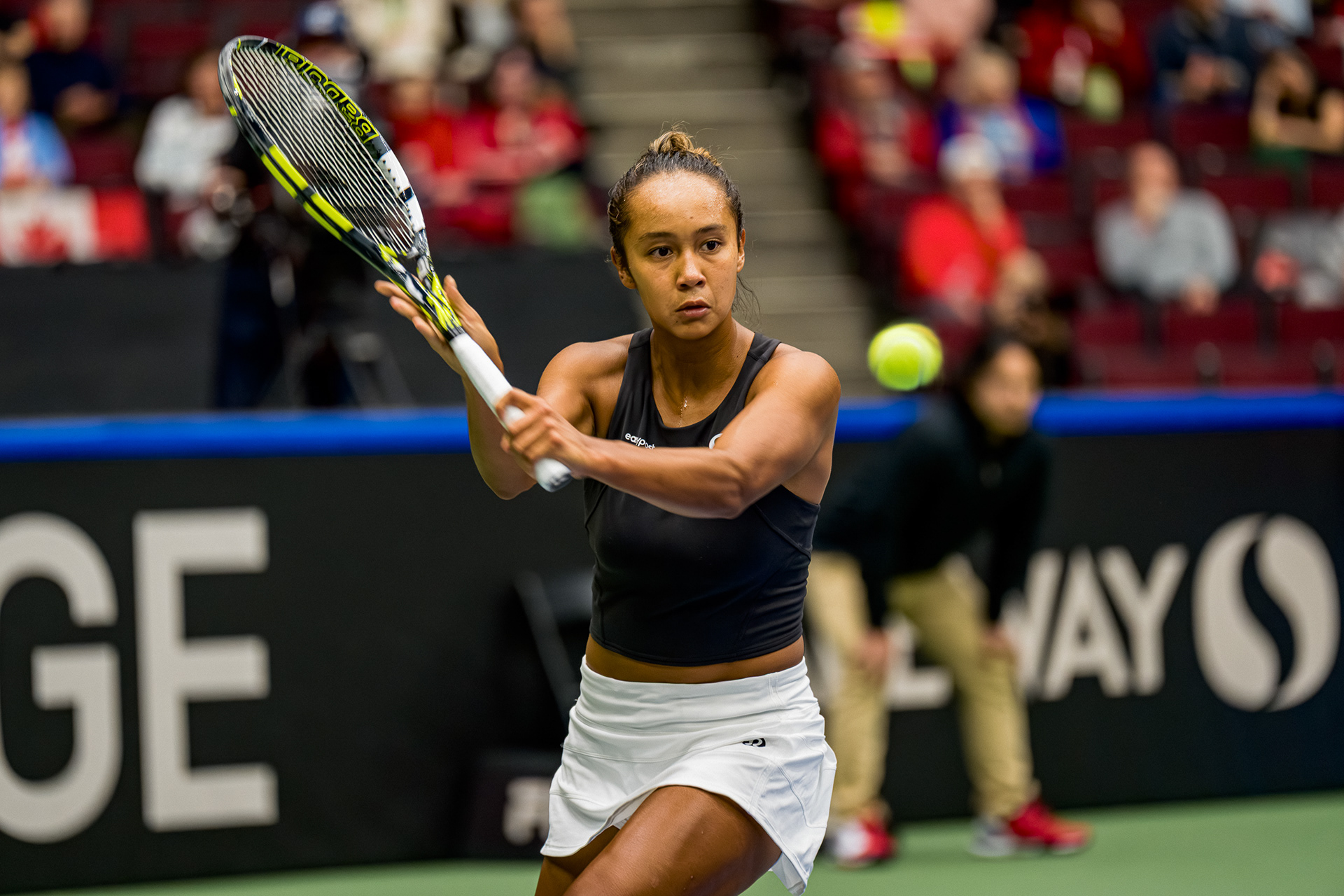 Professional tennis player Leylah Fernandez executing a powerful backhand stroke with intense focus at the Pacific Coliseum in Vancouver, BC. High-speed 50MP sports editorial photography captured on Sony A1 by Joe Ng.