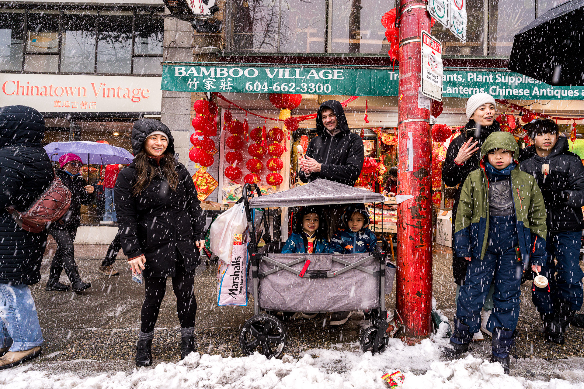 Family with children in a wagon outside Bamboo Village in the snow.
