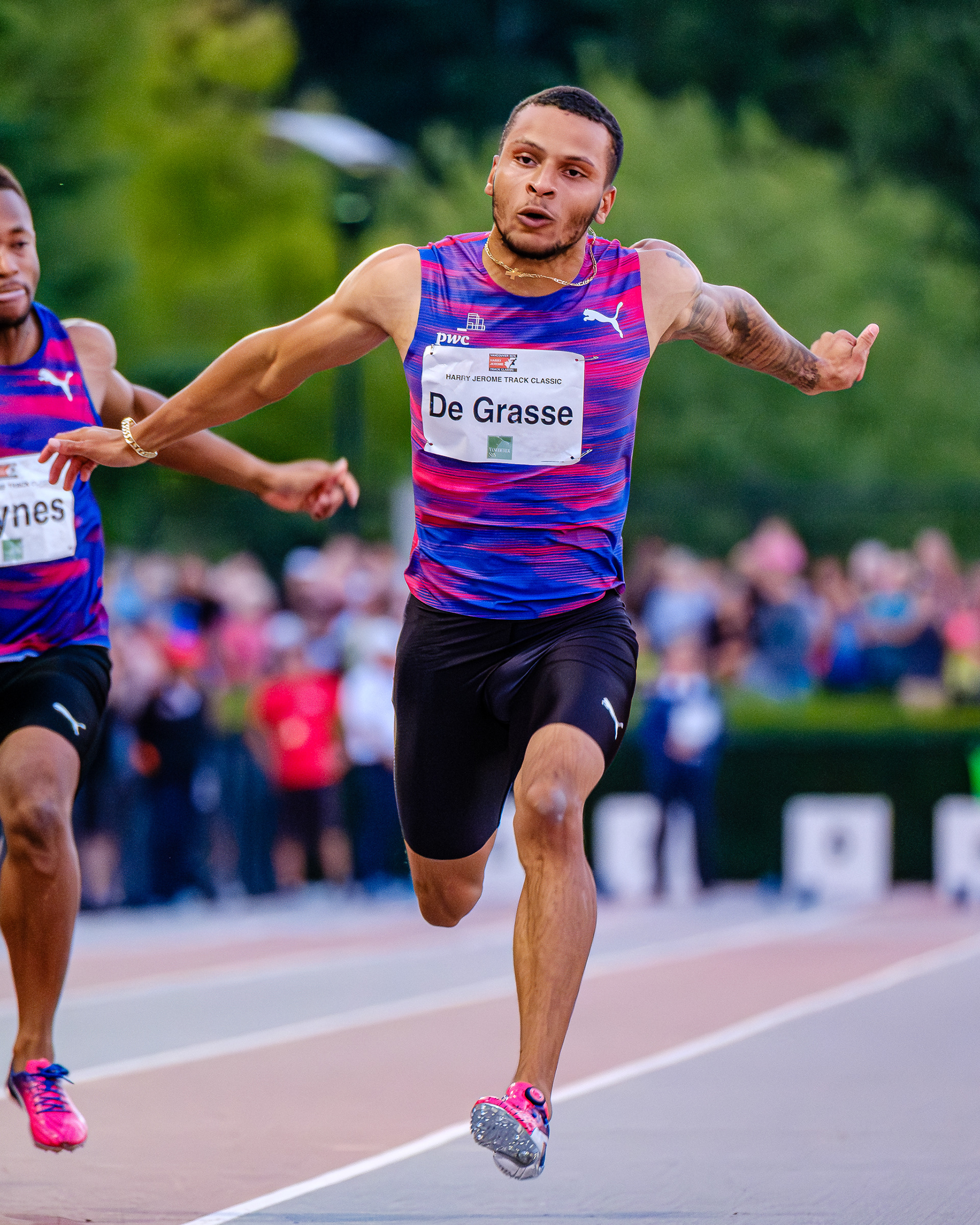 Olympic gold medalist Andre De Grasse at the absolute apex of his stride. High-velocity sports photography capturing human power, athletic determination, and the architecture of speed.