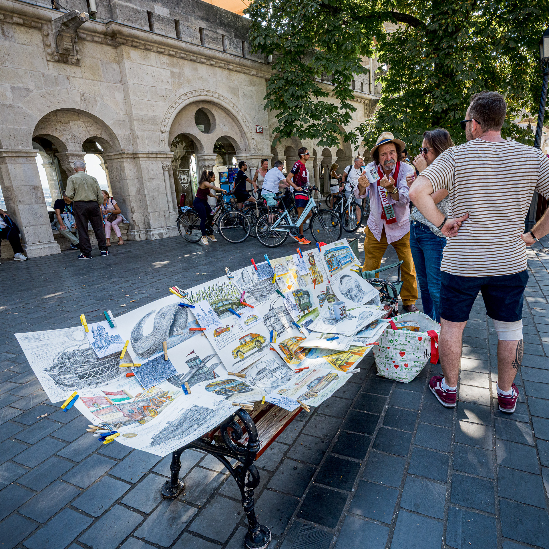 A street artist displaying pencil sketches on a bench at Fisherman's Bastion.