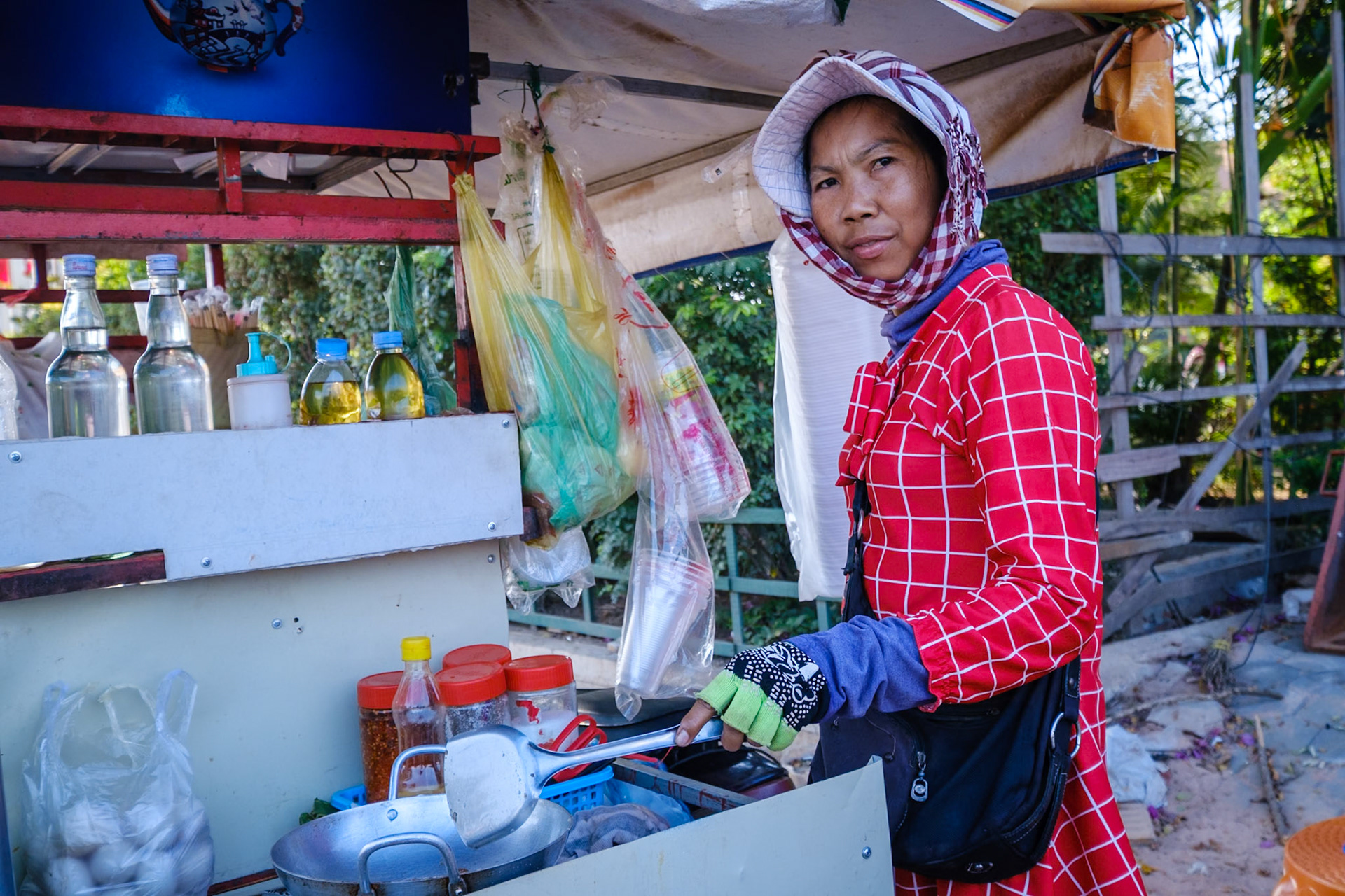 Street food shop keeper cooking food at her stall in Siem Reap, Cambodia.