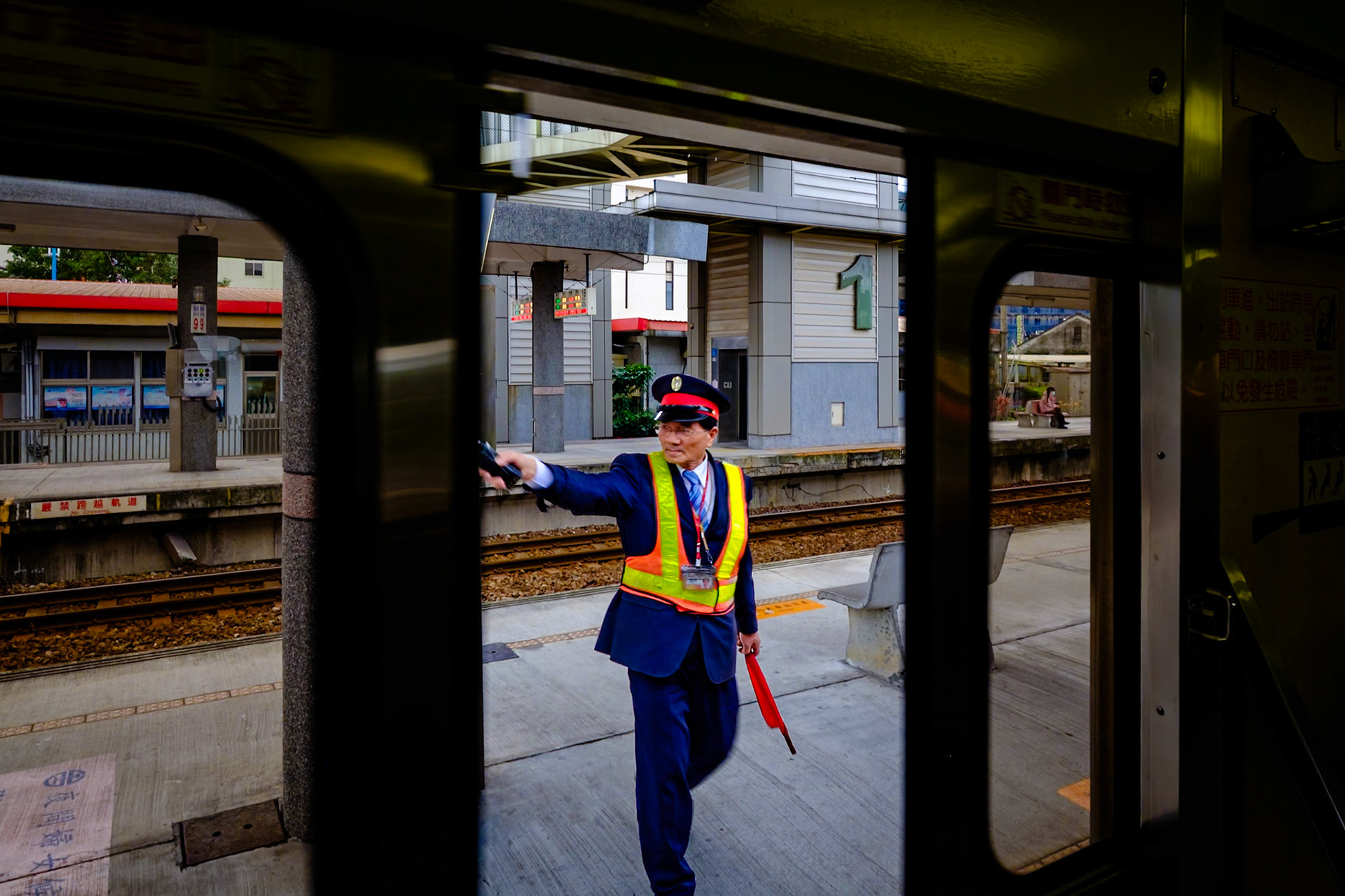 A train station staff signals at Jiaoxi railway station in Yilan County, Taiwan.