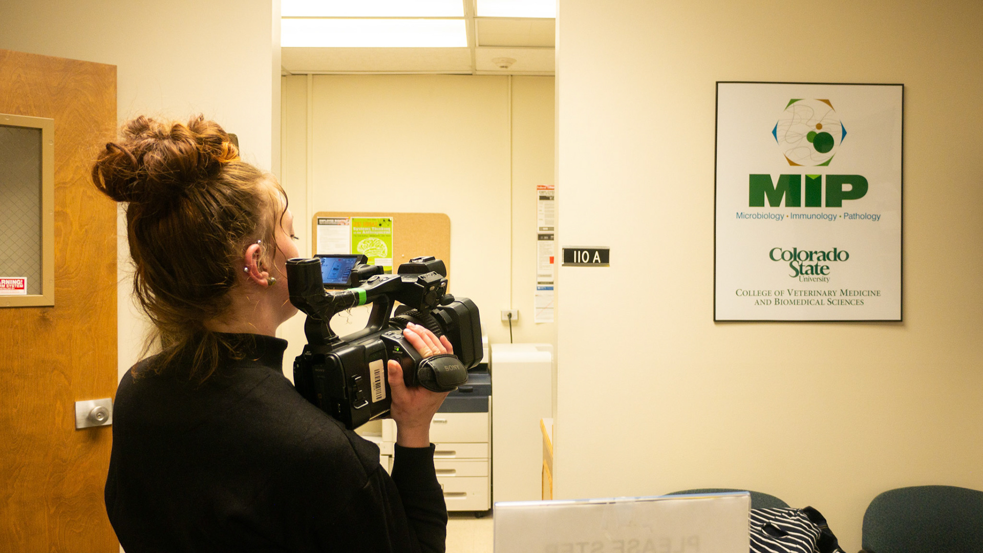 Ren Wadsworth grabs a shot of the Microbiology-Immunology-Pathology sign in the Pathology building at Colorado State University on May 2nd, 2022.