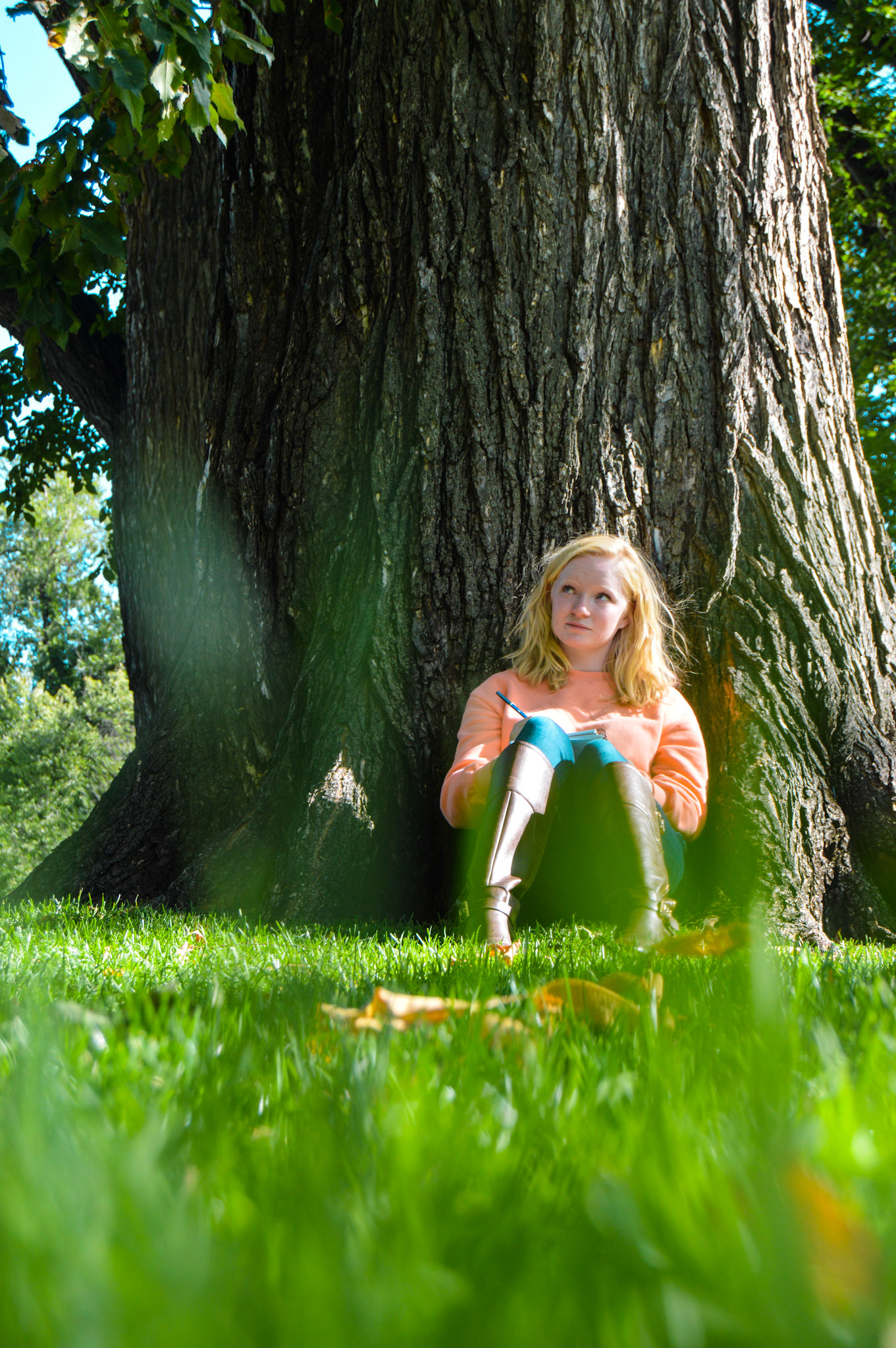 Darby Voorhees sits up against a tree doodling a neighbor tree. She loves to doodle plants and feels in her element when she is with them.