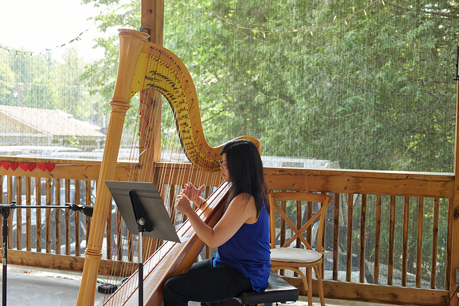 Nicole Chang playing the harp in an outdoor setting.