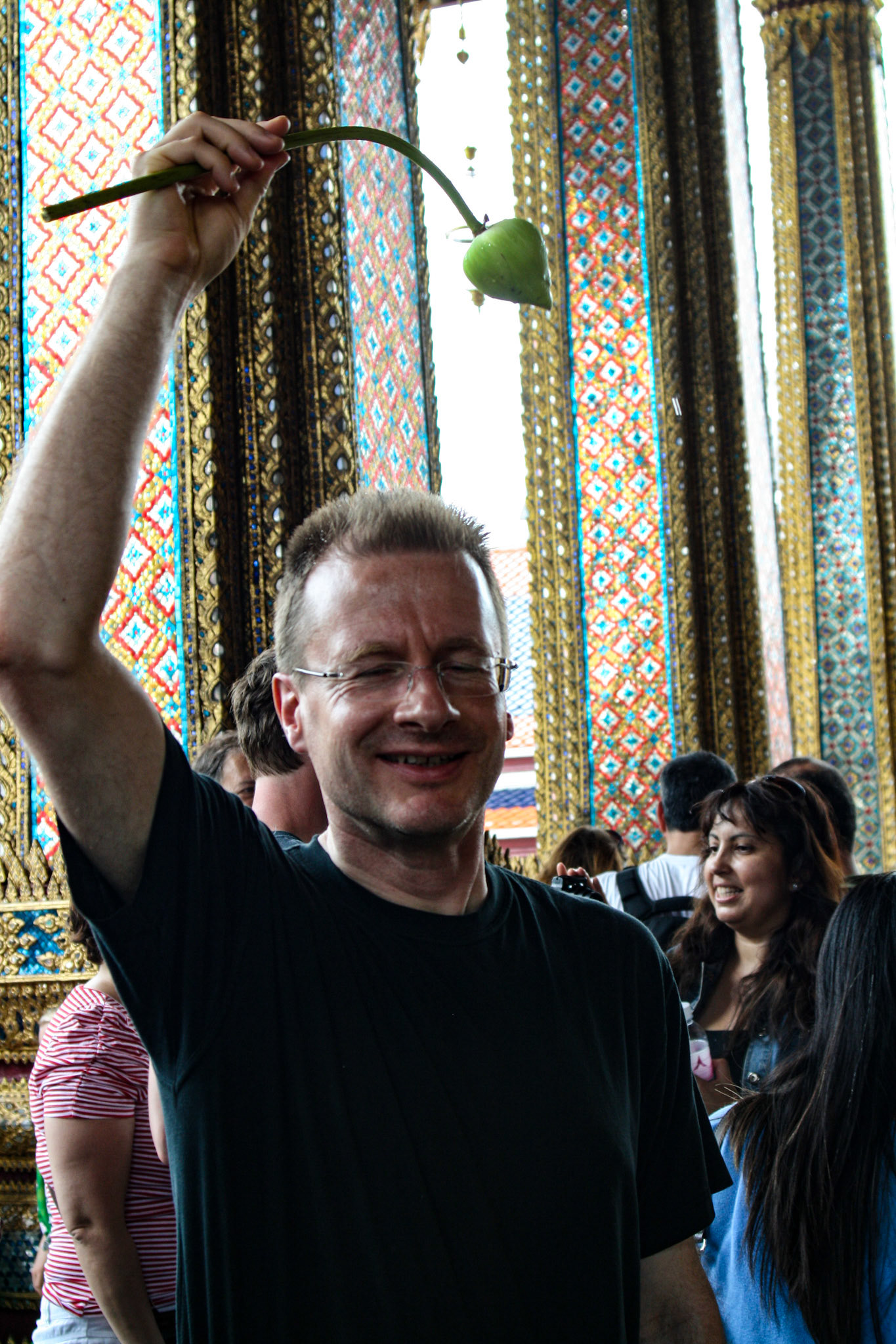 Michael Meffert sprinkles himself with sacred water with a lotus bloom at Wat Phra Kaew.