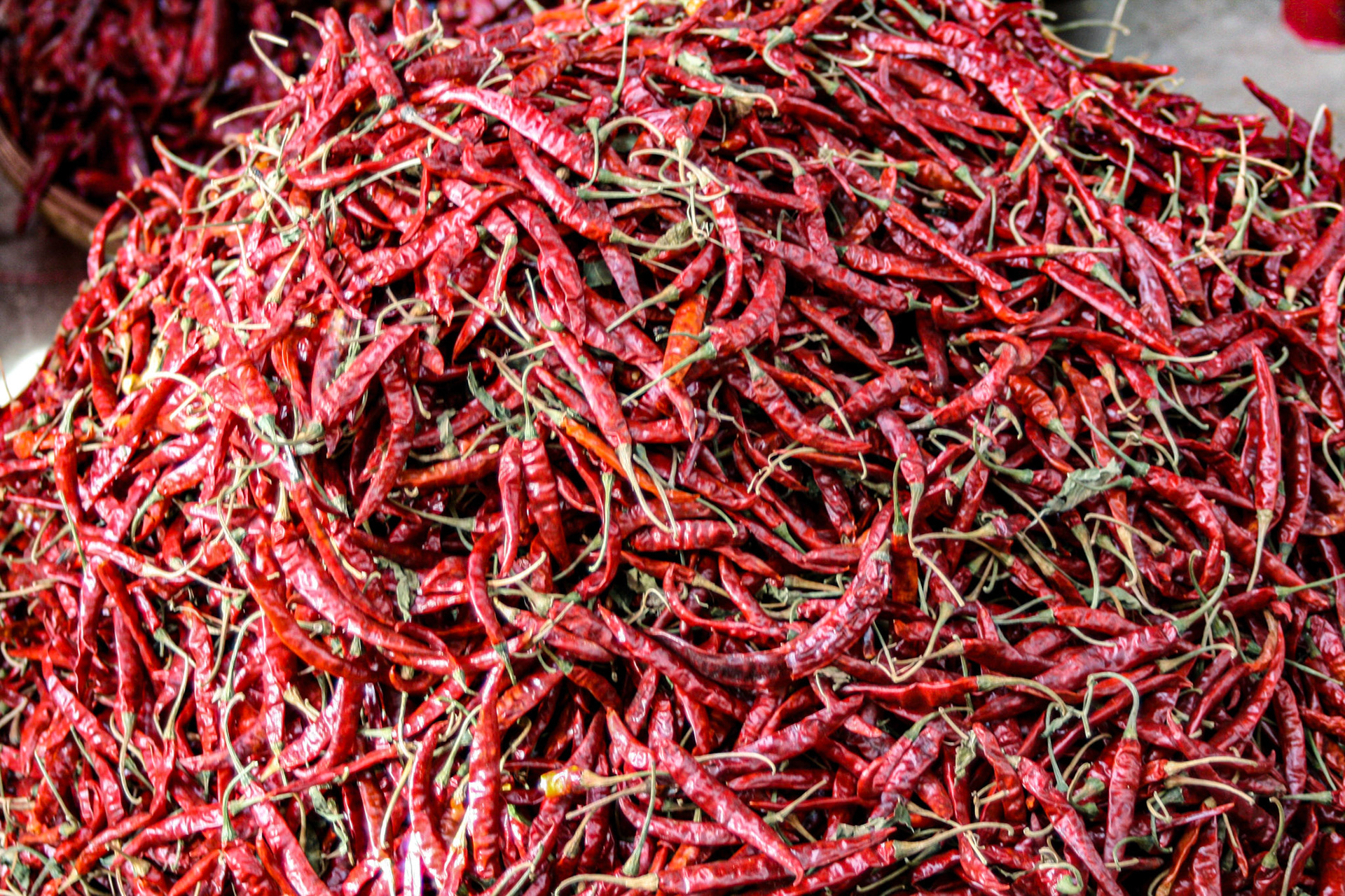 Chilis and other vegetables in big brightly colored piles, a variety of dried spices, pastes and herbs, and other local foods are available in what looks to be a plentiful supply.