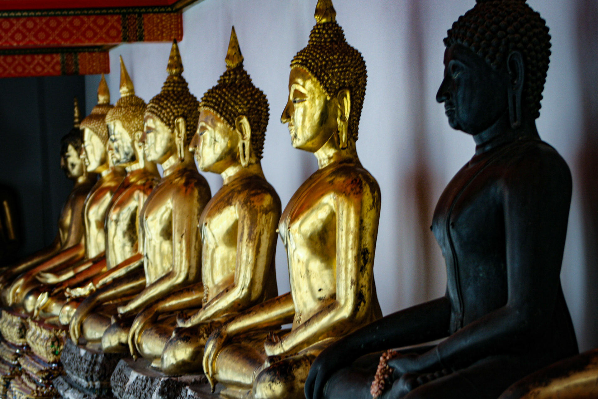 Row of Buddha statues lined up at Wat Pho in Bangkok, Thailand.