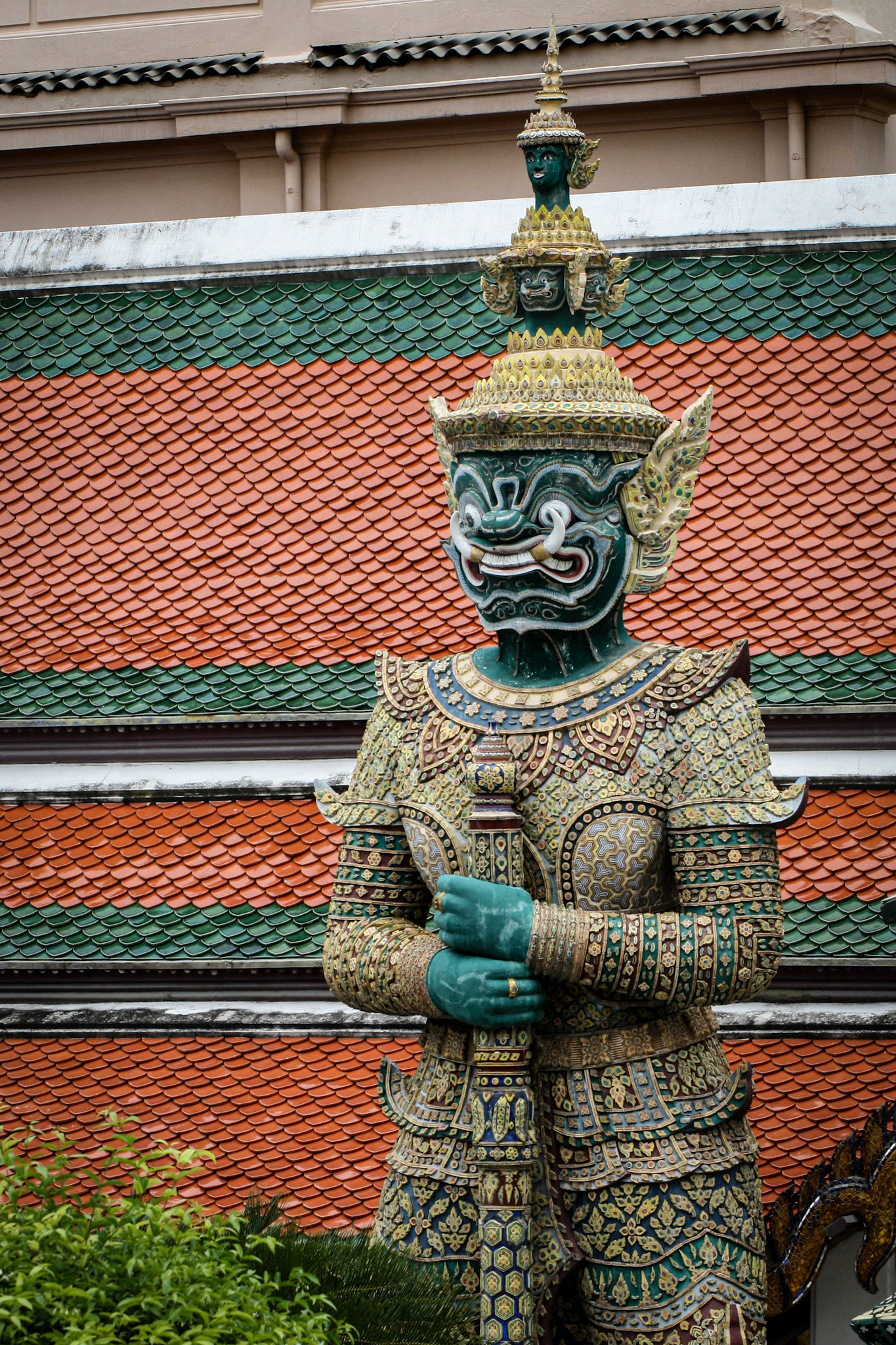 Six pairs of giant demon guardians flank all entrances to the Temple of the Emerald Buddha in Bangkok, Thailand. They are known as yaksha or in Thai are simply called yak (giant) and they are Buddhist gods that protect against evil spirits. The yaksha were placed there during the reign of Rama III. 