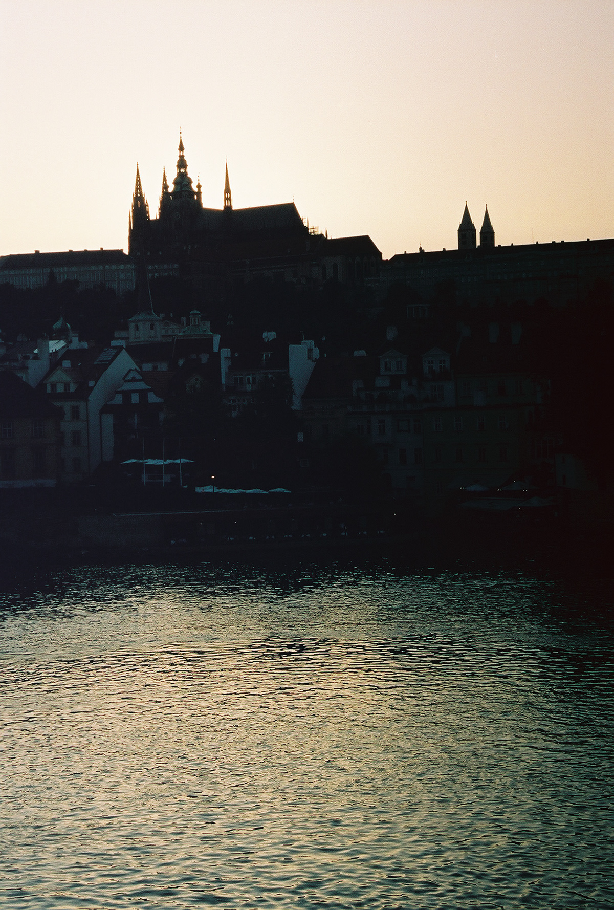 Prague Castle and St. Vitus Cathedral from the Charles Bridge at sunset.