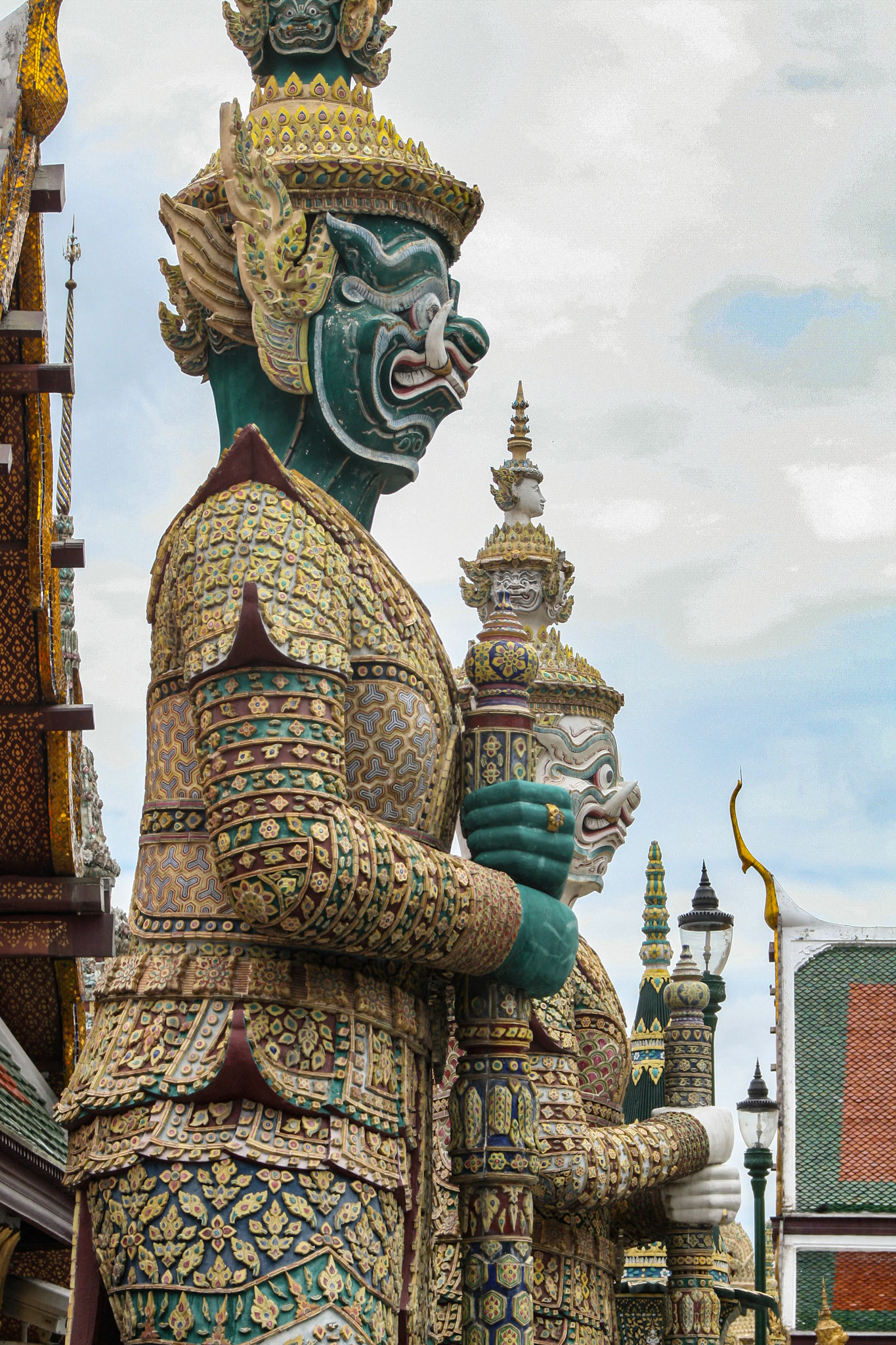 Six pairs of giant demon guardians flank all entrances to the Temple of the Emerald Buddha in Bangkok, Thailand. They are known as yaksha or in Thai are simply called yak (giant) and they are Buddhist gods that protect against evil spirits. The yaksha were placed there during the reign of Rama III. 
