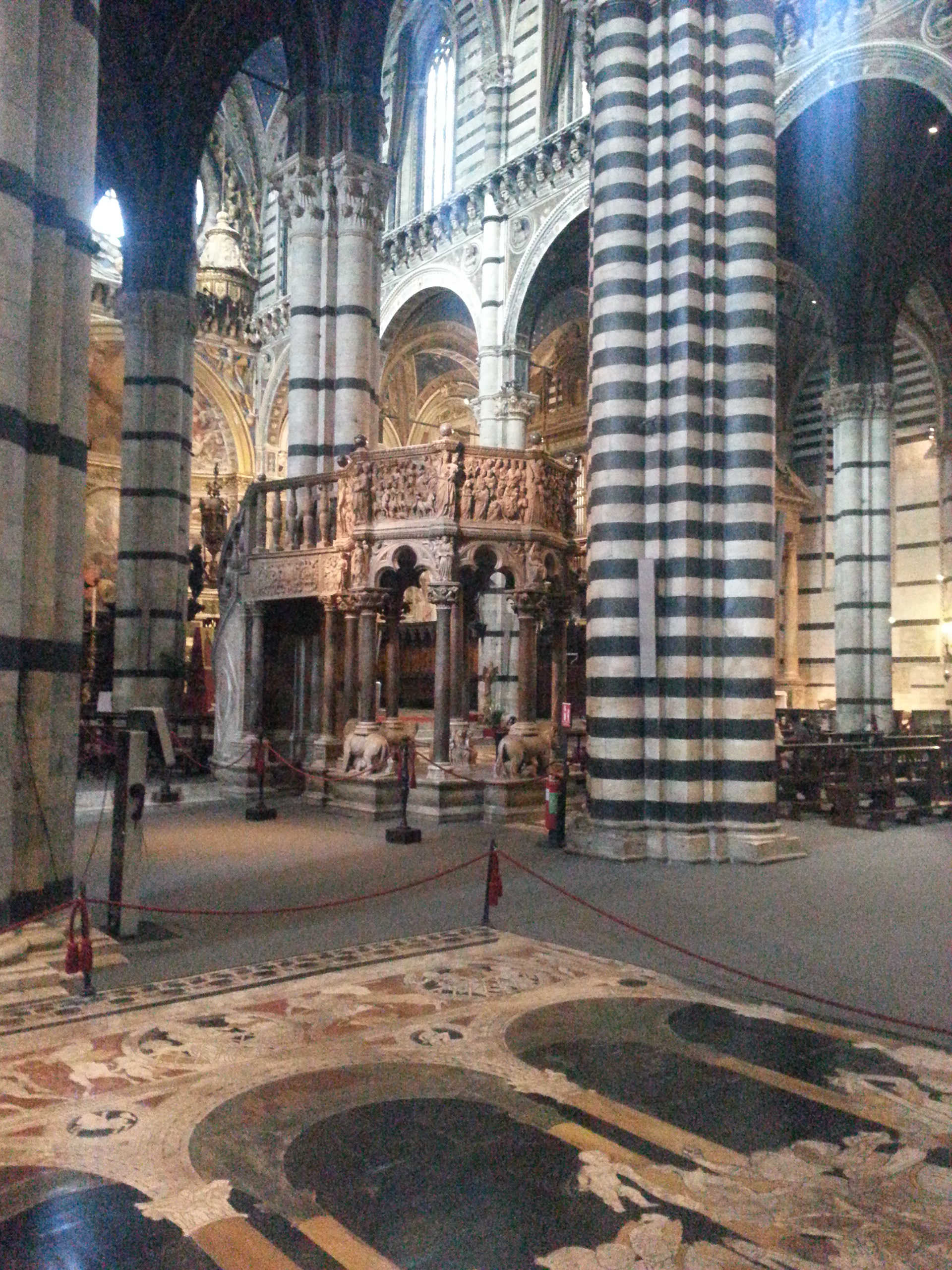The Siena Cathedral Pulpit is an octagonal structure in Siena Cathedral sculpted by Nicola Pisano and his assistants Arnolfo di Cambio, Lapo di Ricevuto, and Nicolas' son Giovanni Pisano between the fall of 1265 and the fall of 1268. The pulpit, with its seven narrative panels and nine decorative columns carved out of Carrara marble, showcases Nicola Pisano's talent for integrating classical themes into Christian traditions, making both Nicola Pisano and the Siena pulpit forerunners of the classical revival of the Italian Renaissance. 
