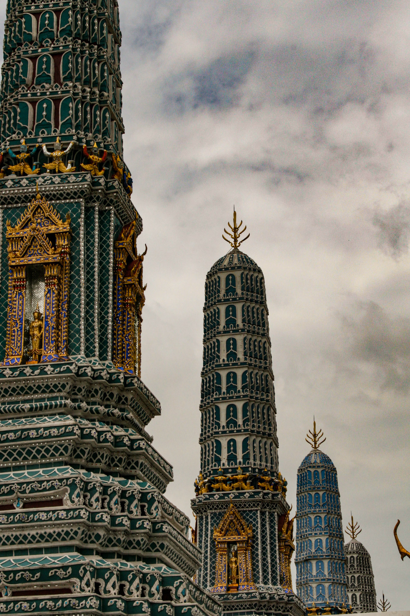 Four Towers Called Prangs or Chedi at Grand Palace in Bangkok, Thailand - These four towers are half of the eight chedis called Phra Atsada Maha Chedis at the eastern side of the Grand Palace. The prangs are ornately decorated with glazed tiles. Their three tiers represent hell, humanity and Nirvana. Each of these prangs also connote a different Buddhist concept. 