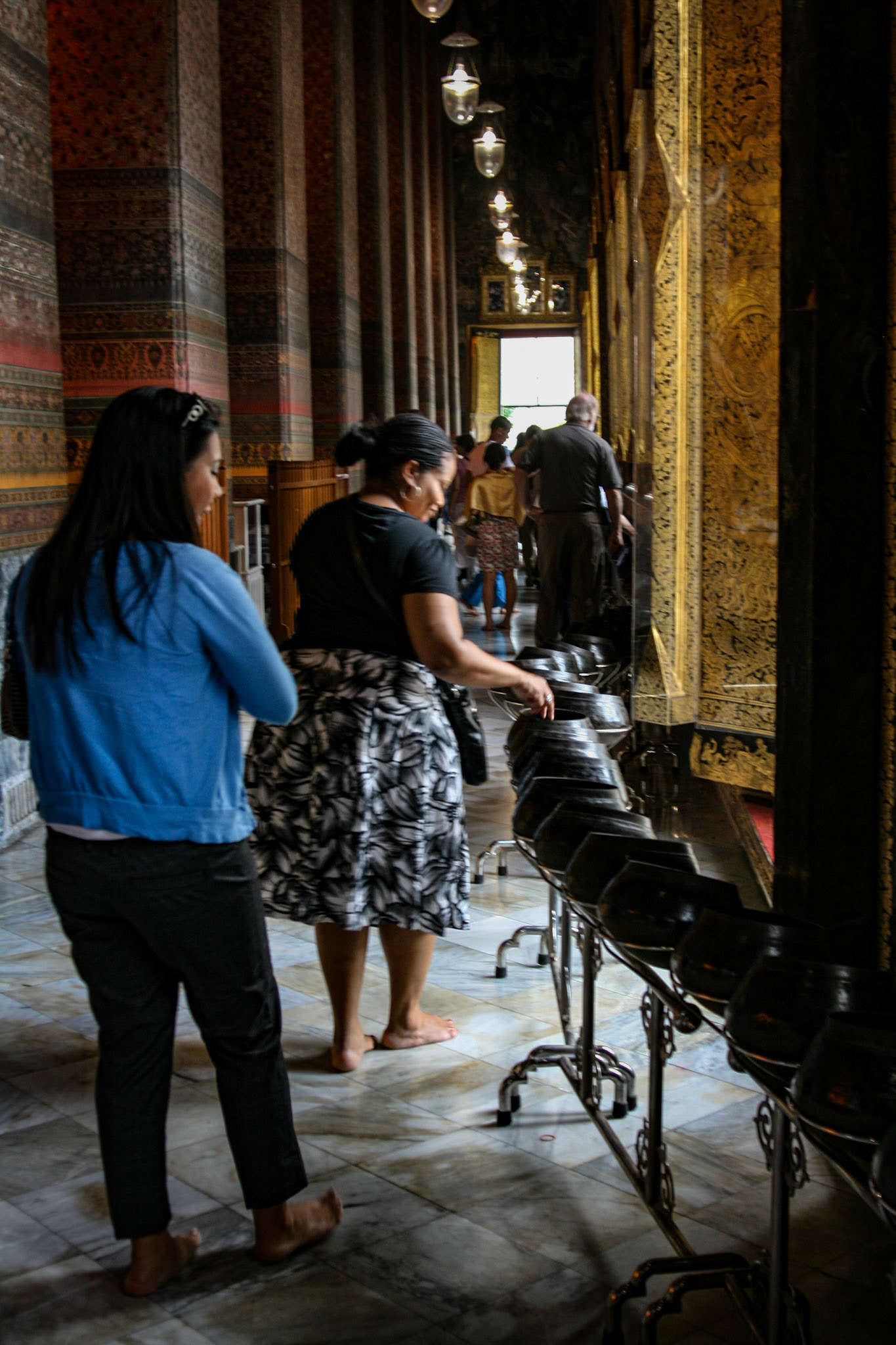 Wat Pho buddhist temple with the 108 bronze bowls indicating 108 auspicious characters of Buddha. People drop coins in these bowls to bring good fortune.