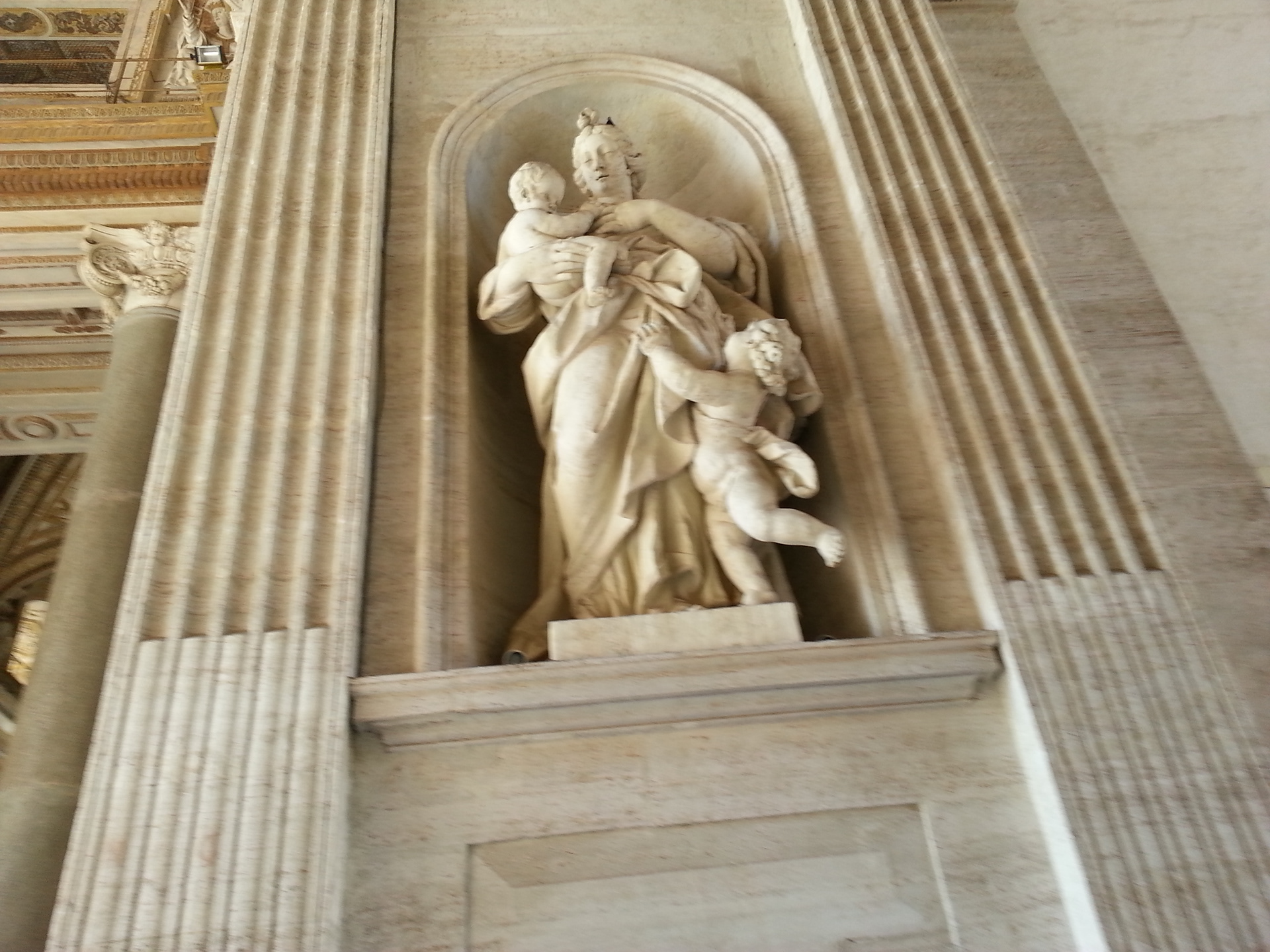 Ancient roman statue of Mother and two children in St. Peter's Portico.