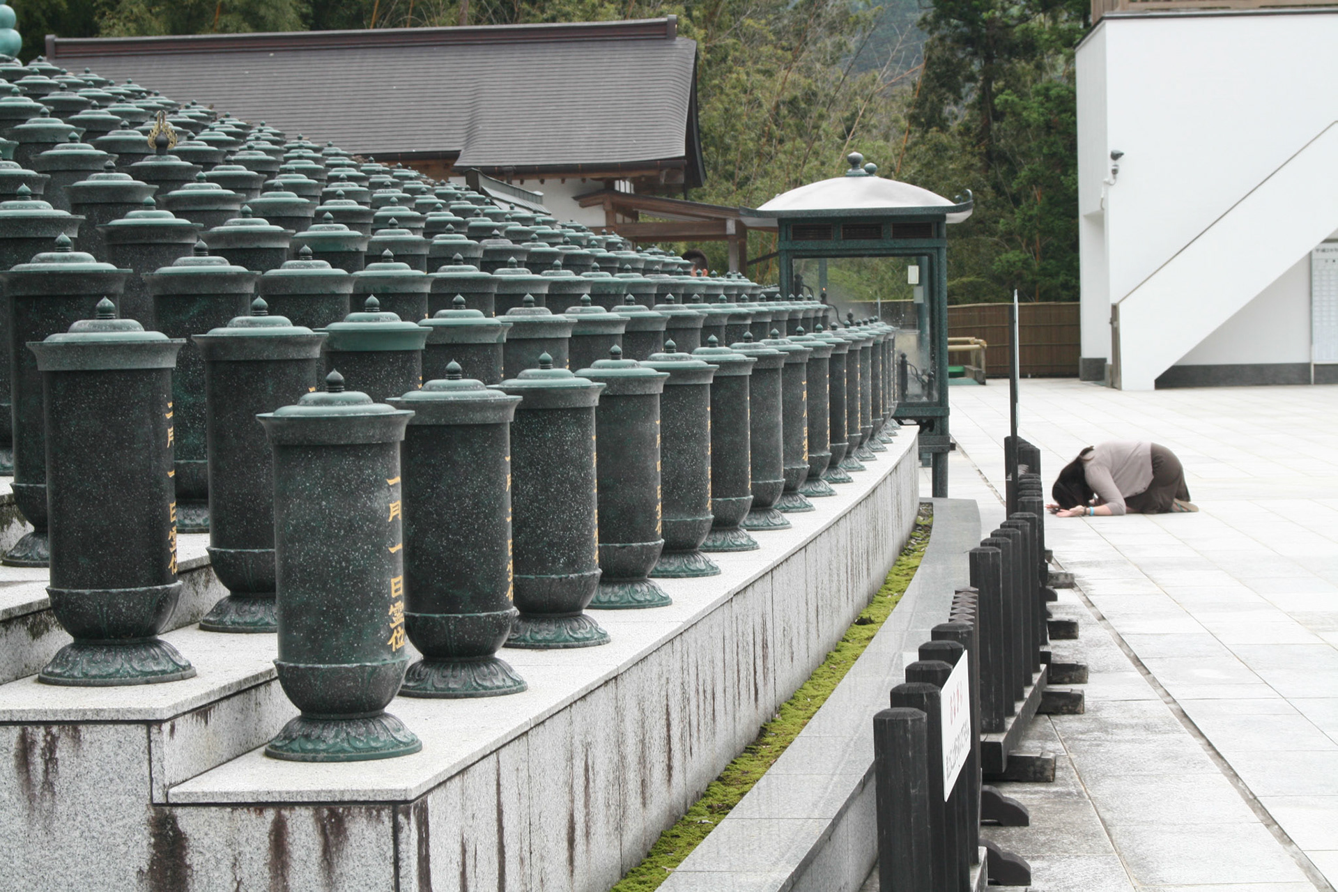 Visitor worshipping in front of the reclining Buddha is dwarfed by its immense size.
