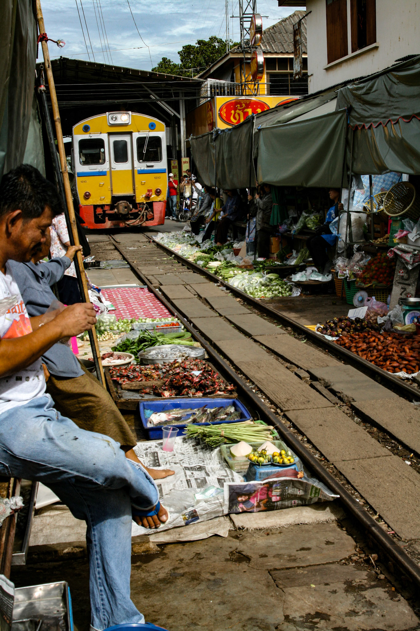 Vendors must hold the poles up to allow the train room to pass.
